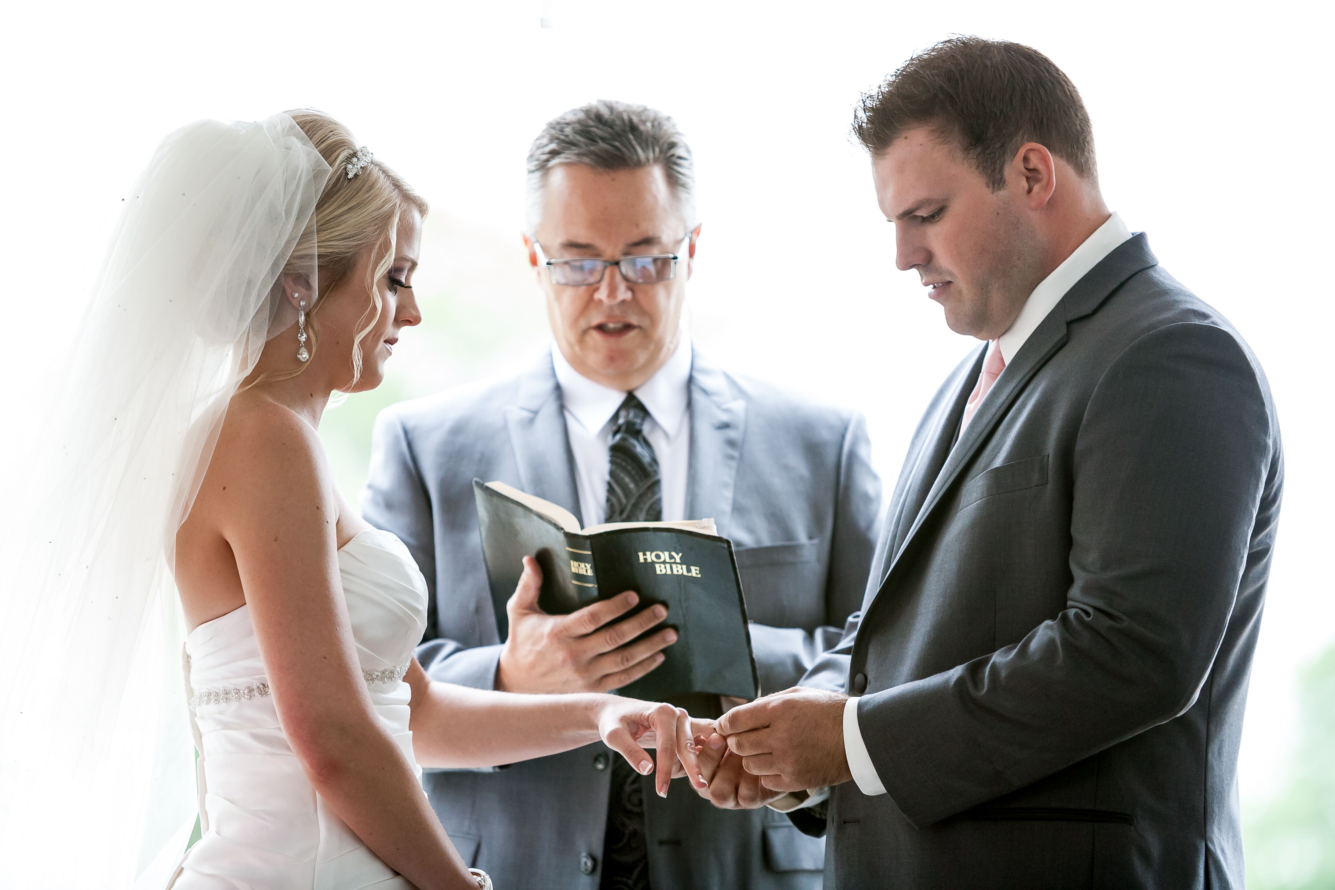 Groom Putting Wedding Ring On Bride