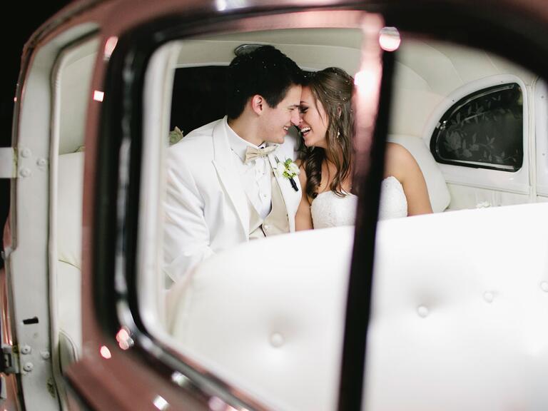 Bride and groom in vintage getaway car