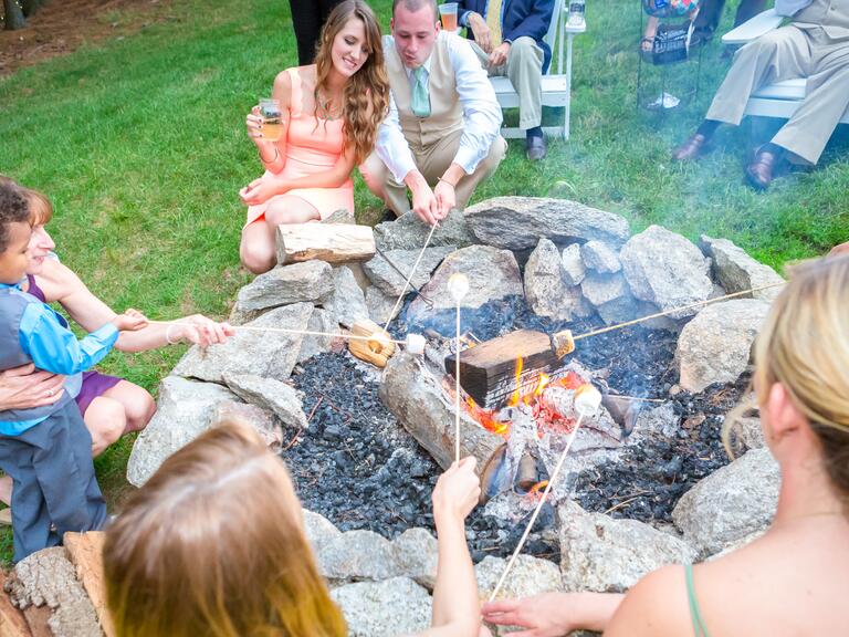 Reception bonfire with guests roasting s'mores