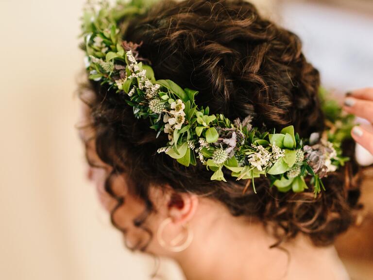 Flores del pelo de la boda moño rizado con corona de greenery