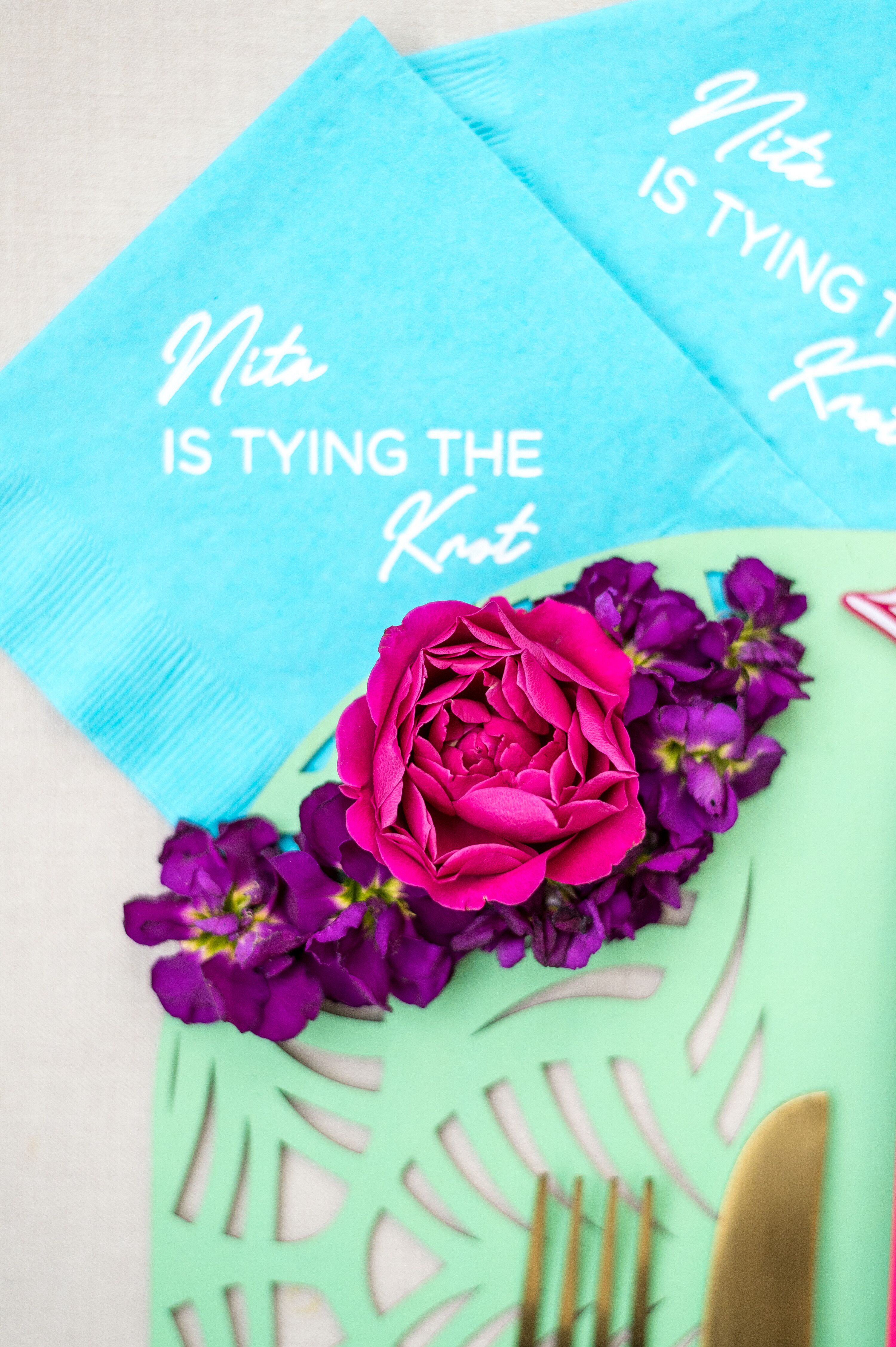 Personalized Blue Napkins And Bright Flowers on Turquoise Mat for