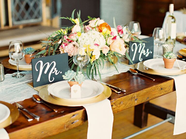 Mr. and Mrs. slate signs on rustic wooden reception table