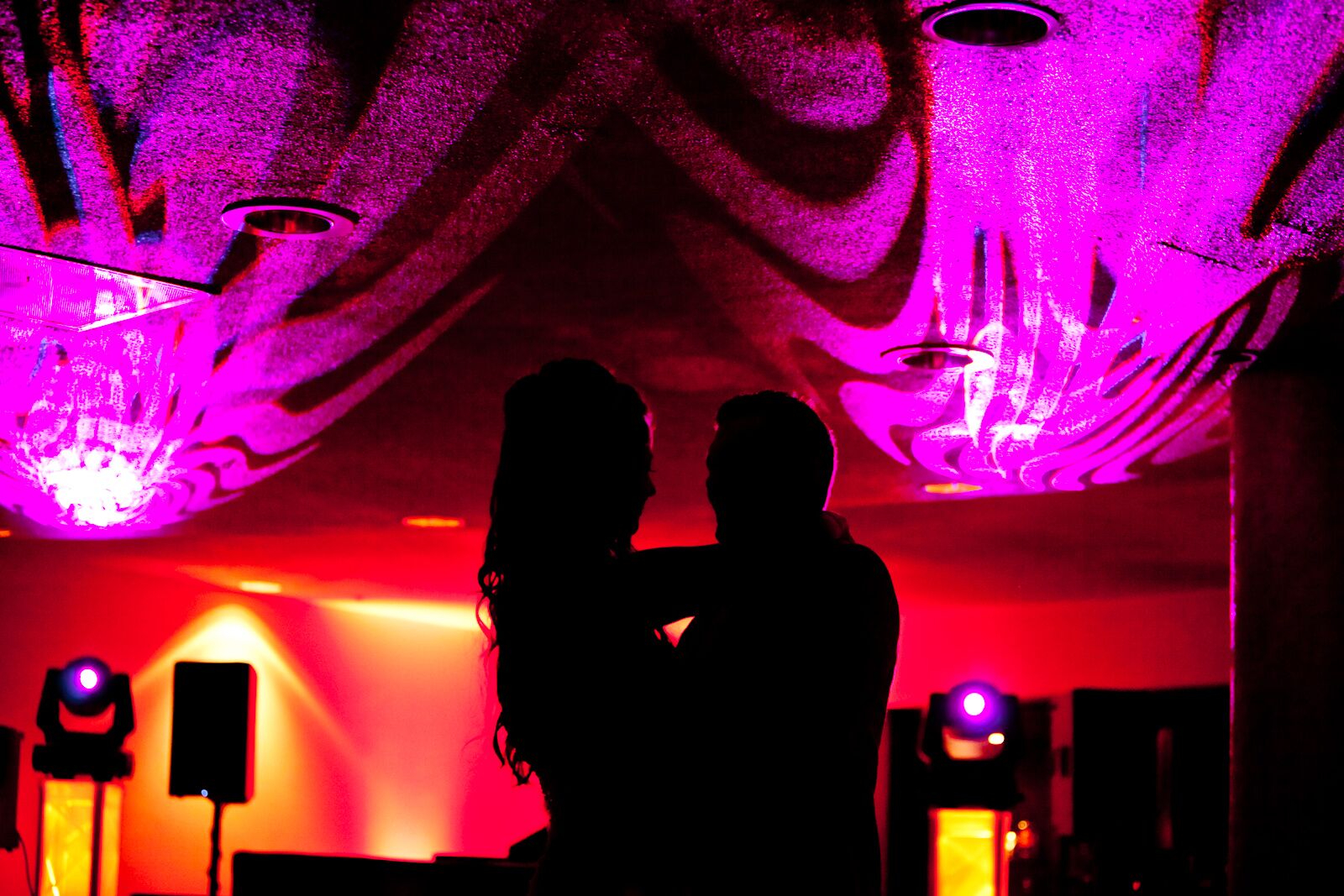 First Dance Silhouetted by Bright Pink and Red Lighting