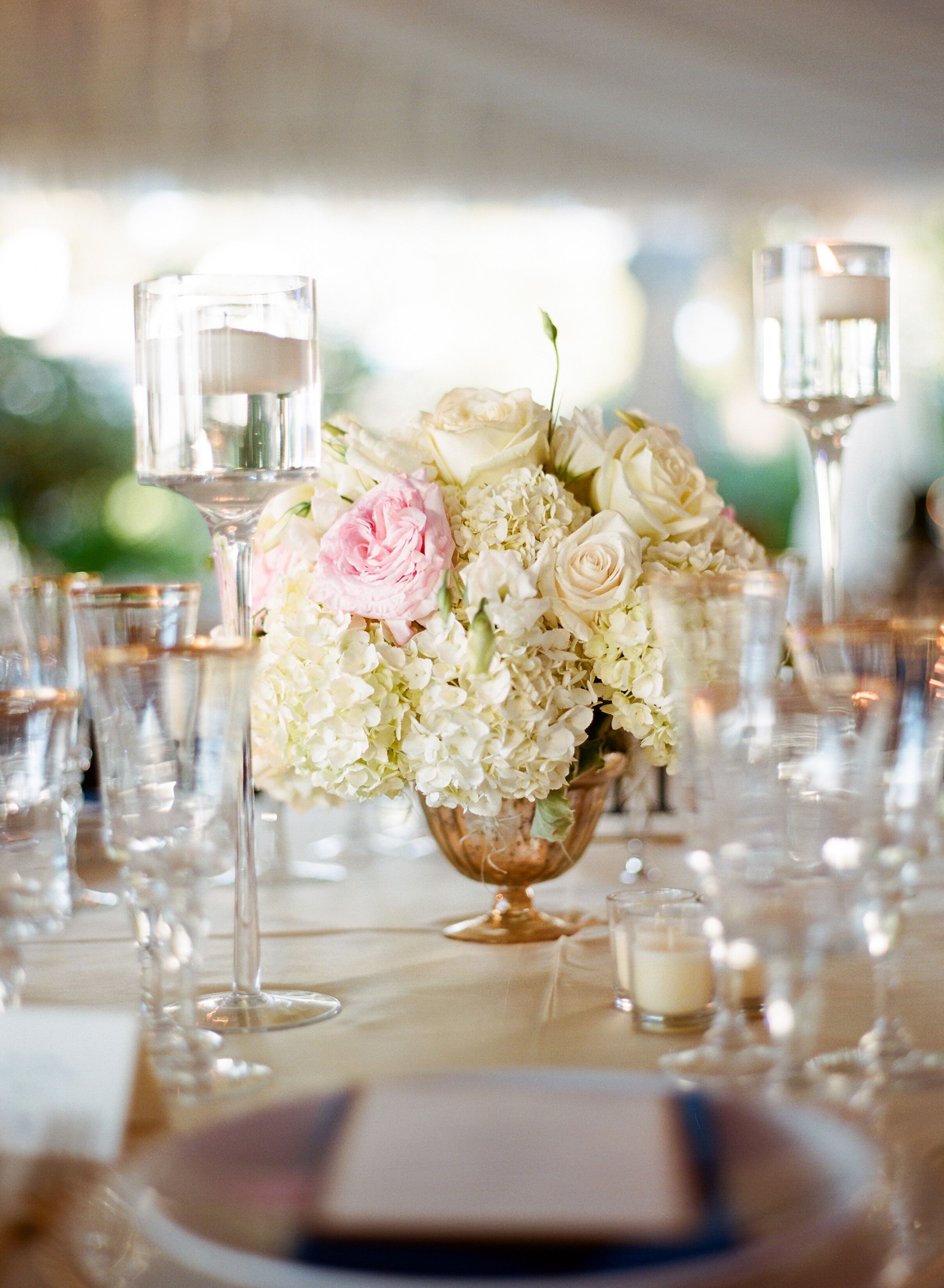 Gold Urn Centerpieces Filled with Ivory Arrangements