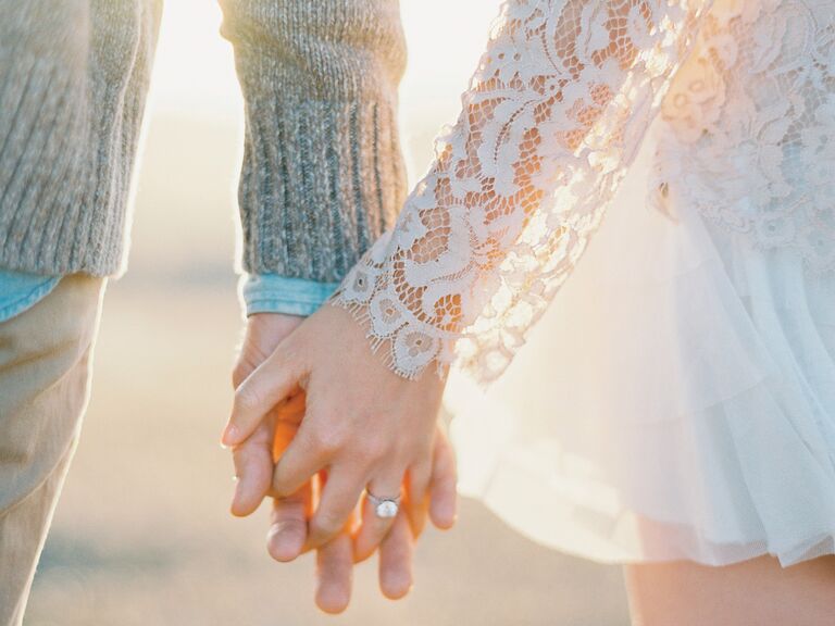 Newly engaged couple holding hands