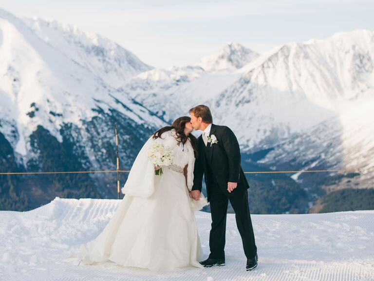 newlyweds kissing on a mountaintop in Alaska