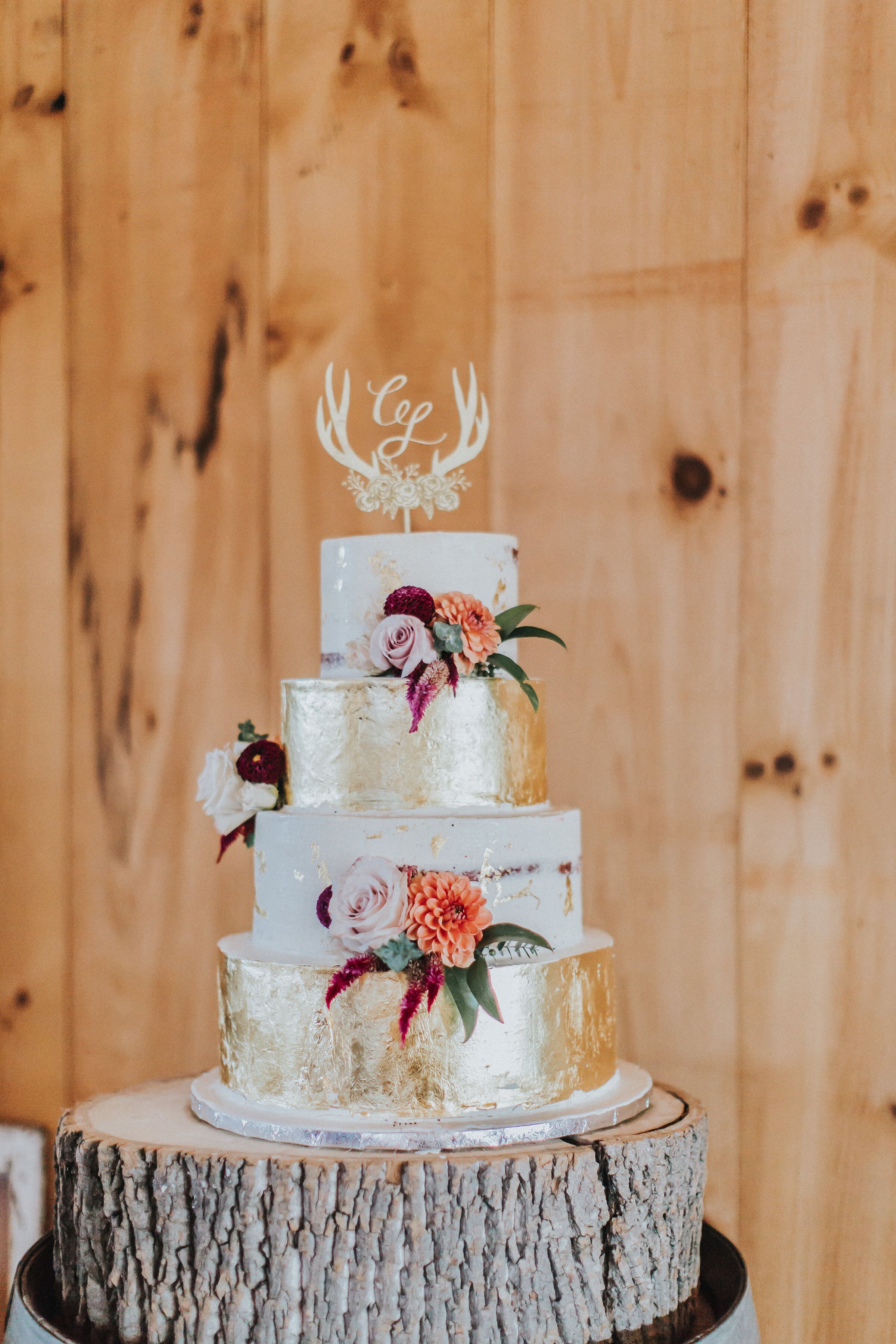 Elegant Tiered Cake with Antler Topper and Gold Leaf Layers