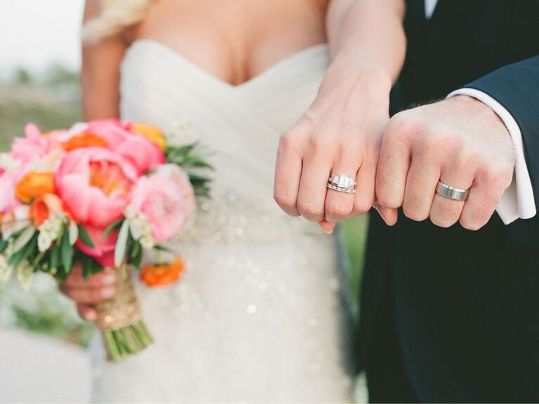 recién casados mostrando anillos de boda