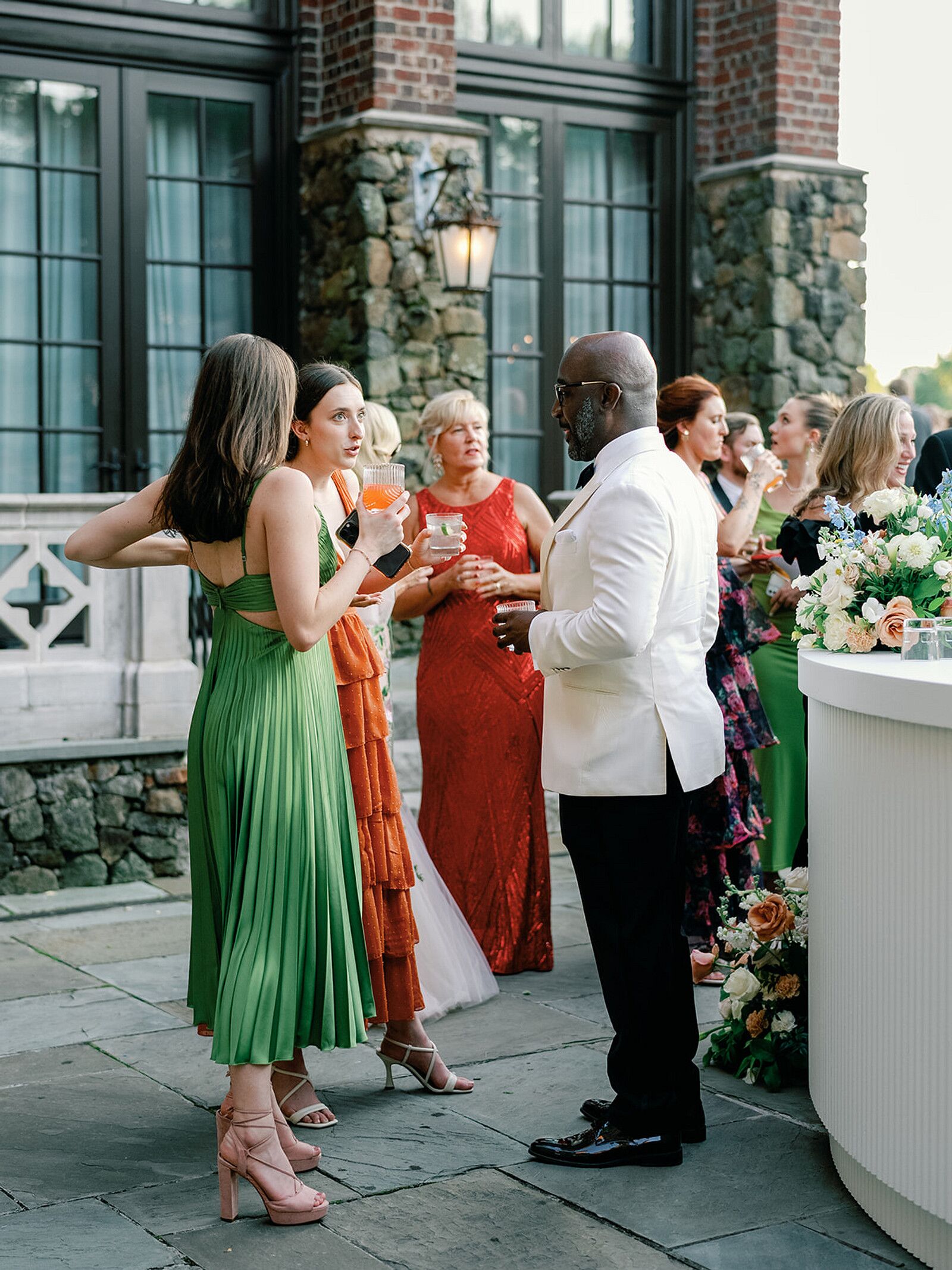 guests-in-formal-attire-mingling-on-castle-estate-veranda-at-cocktail-hour