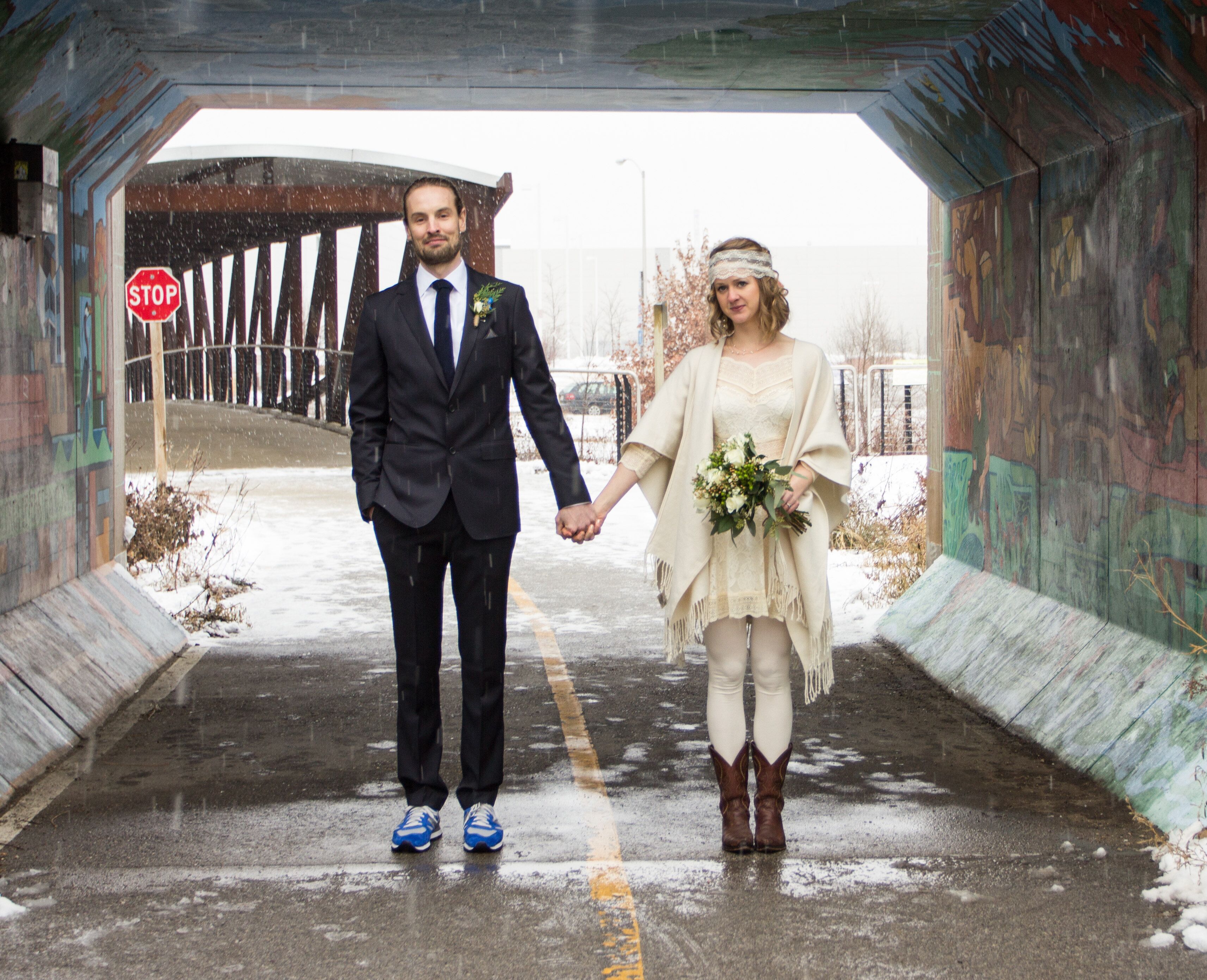 Groom In Suit And Sneakers And Bohemian Bride In Short Wedding Dress