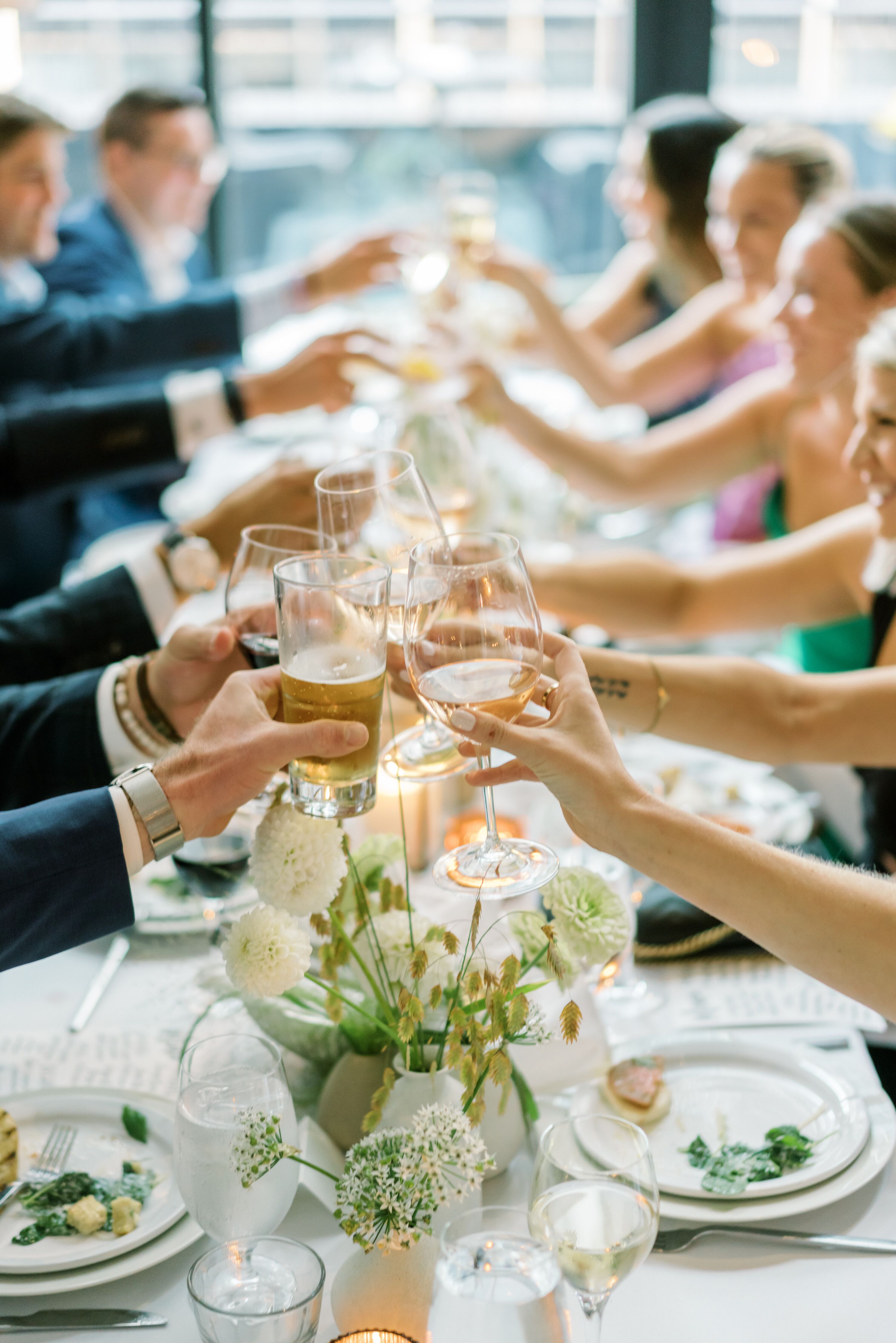 Rehearsal Dinner Guests at Long Table, White Linen Cheers Glasses of ...
