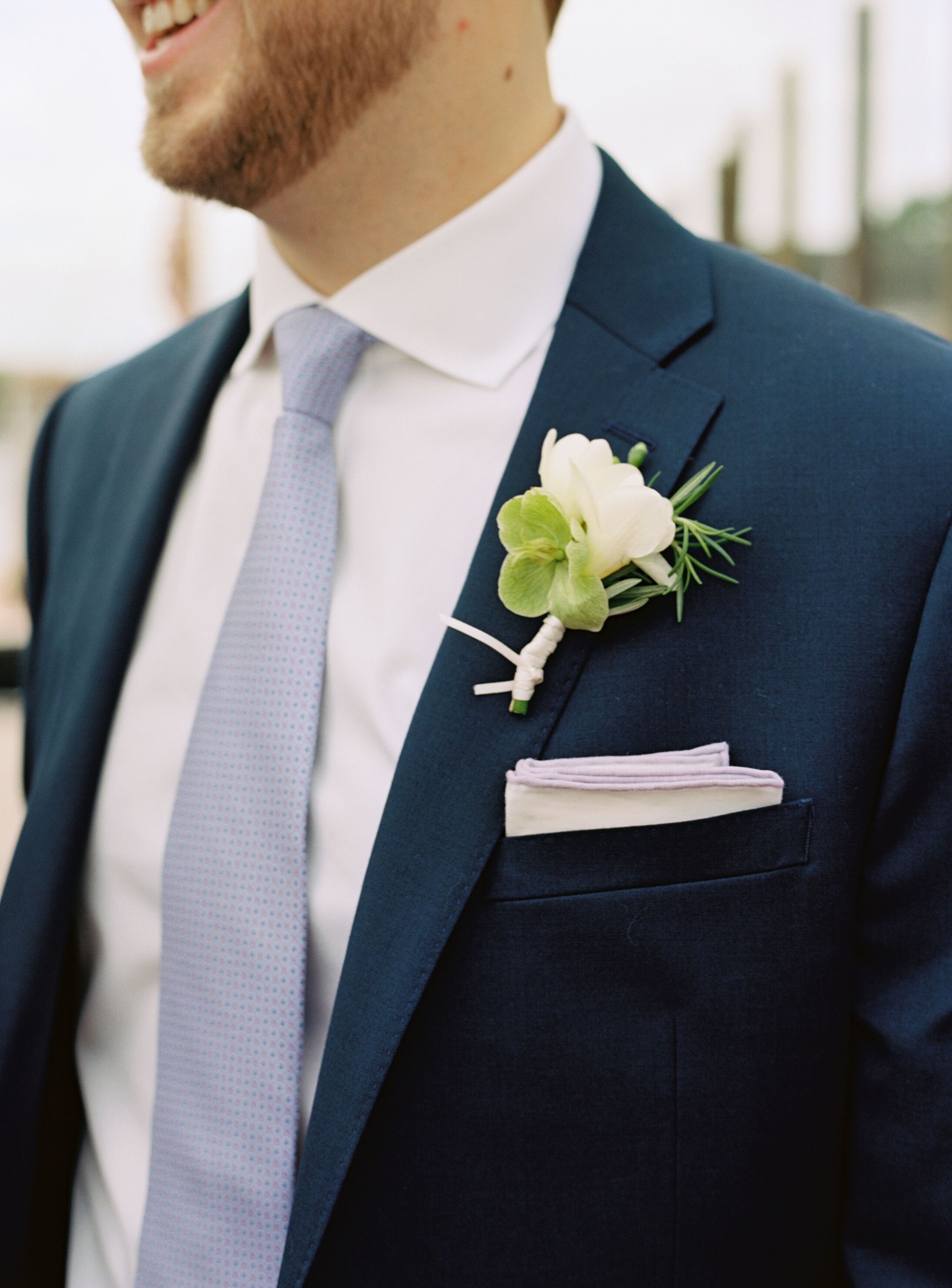 Sweet Pea Boutonniere Against Navy Suit