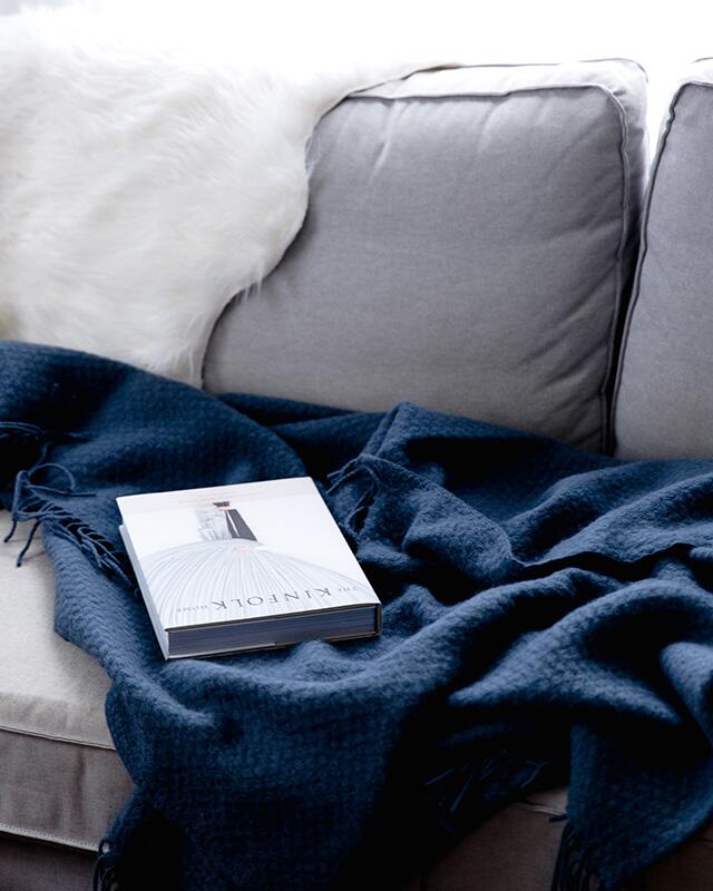 grey couch with blue blanket