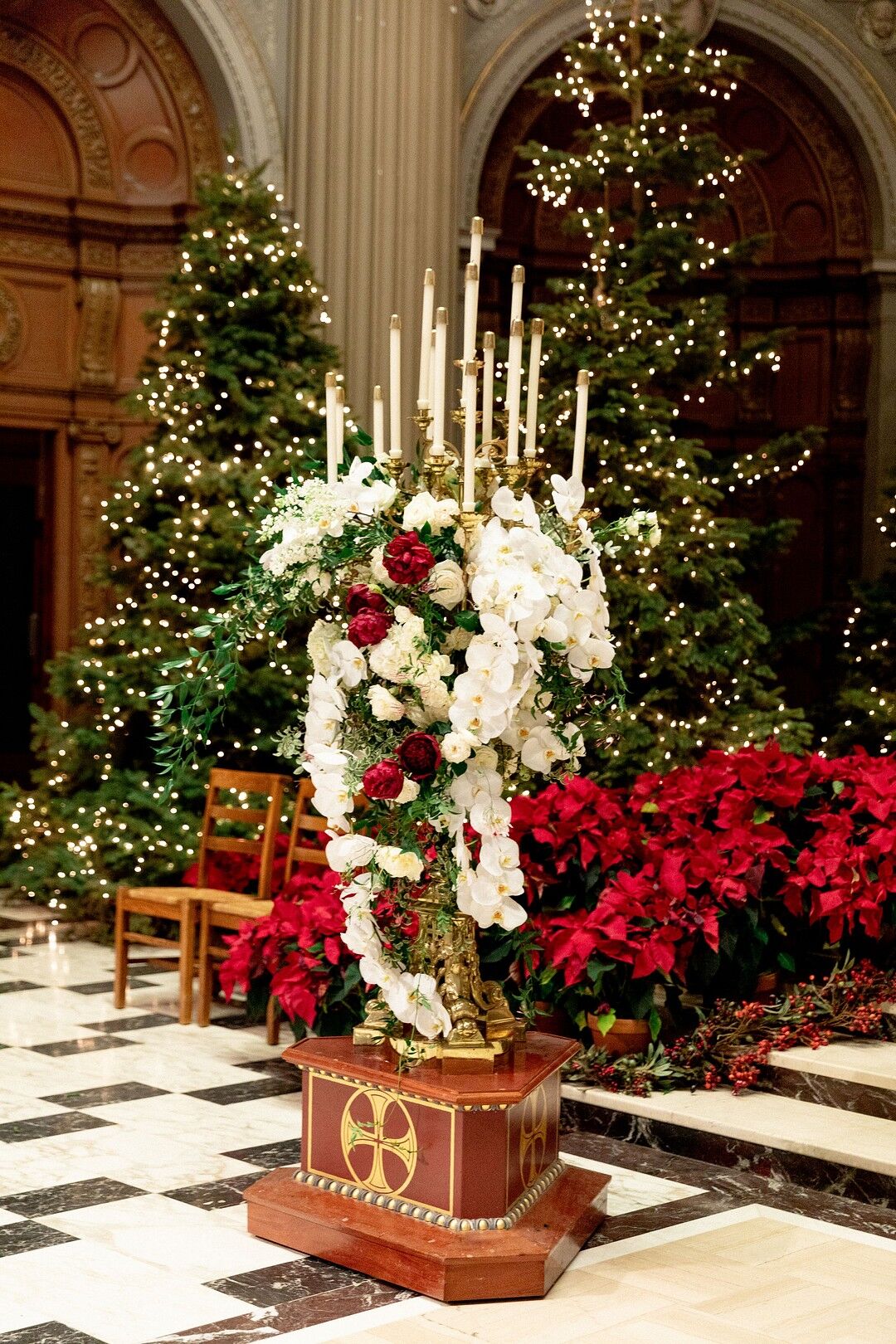 Church Altar with Red and White Flowers and Lit Christmas Trees