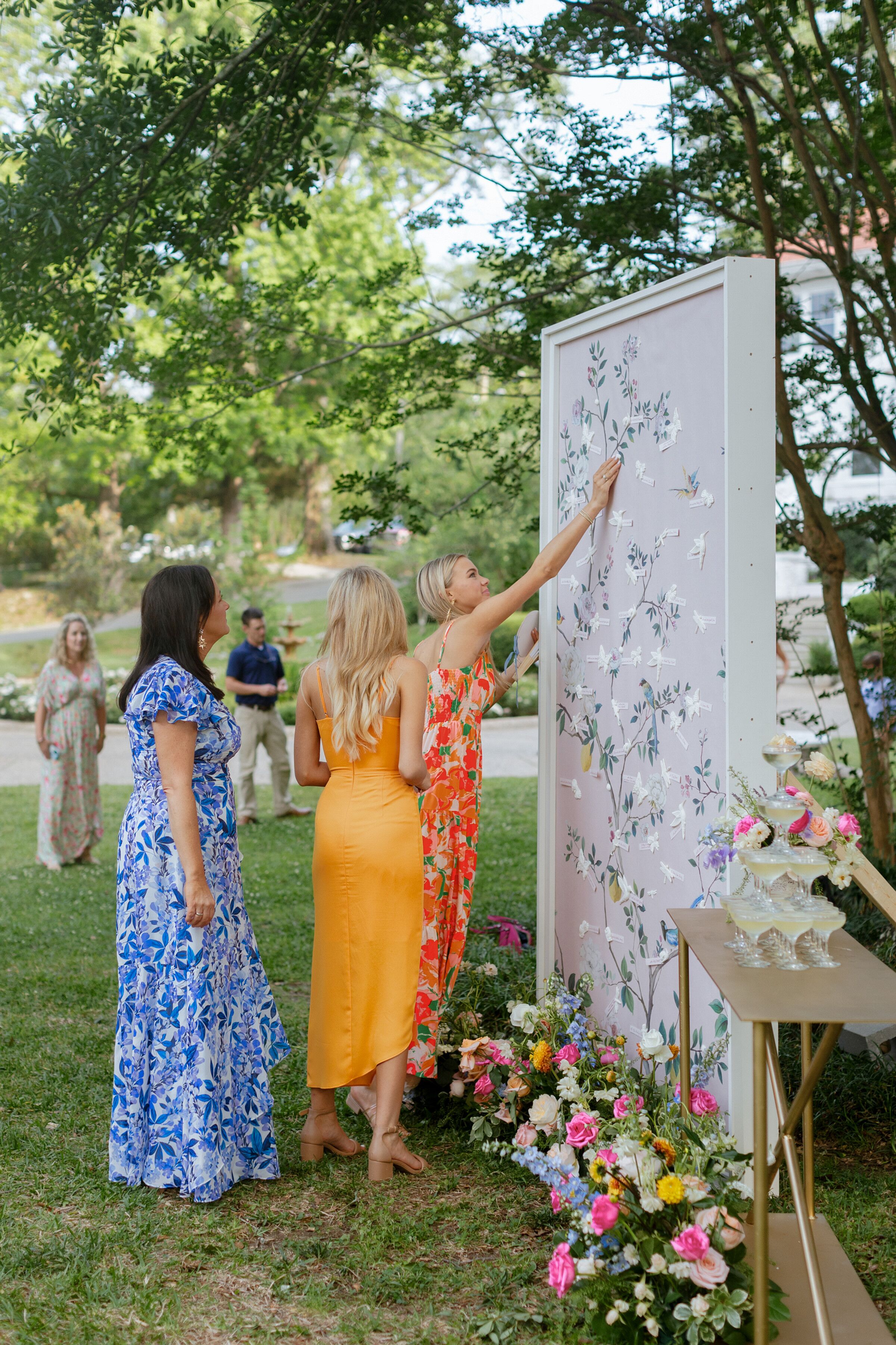 Guests at Outdoor Reception By Purple Seating Chart With Vine Design