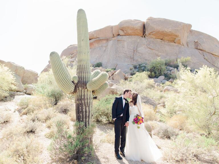 newlyweds kissing next to cactus in Arizona