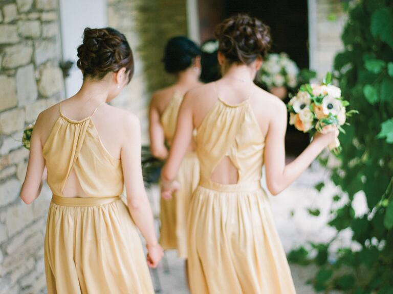 Bridesmaids in gold dresses walking to ceremony