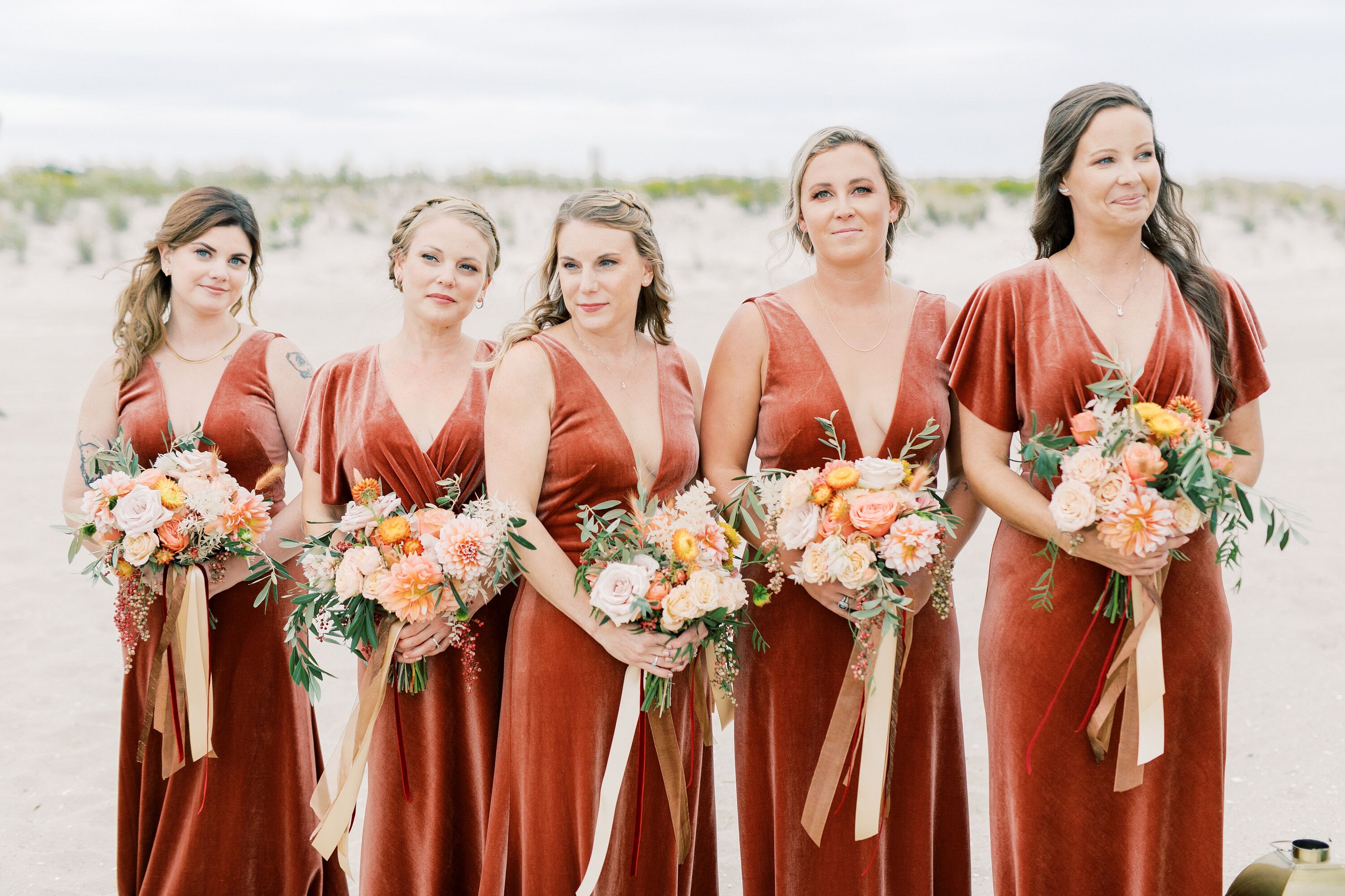 Bridesmaids in Velvet Dresses Carry Bouquets with White Ribbon