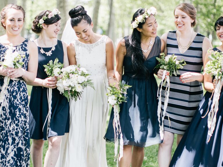 Bride with bridesmaids in mismatched navy blue, striped and patterned bridesmaid dresses