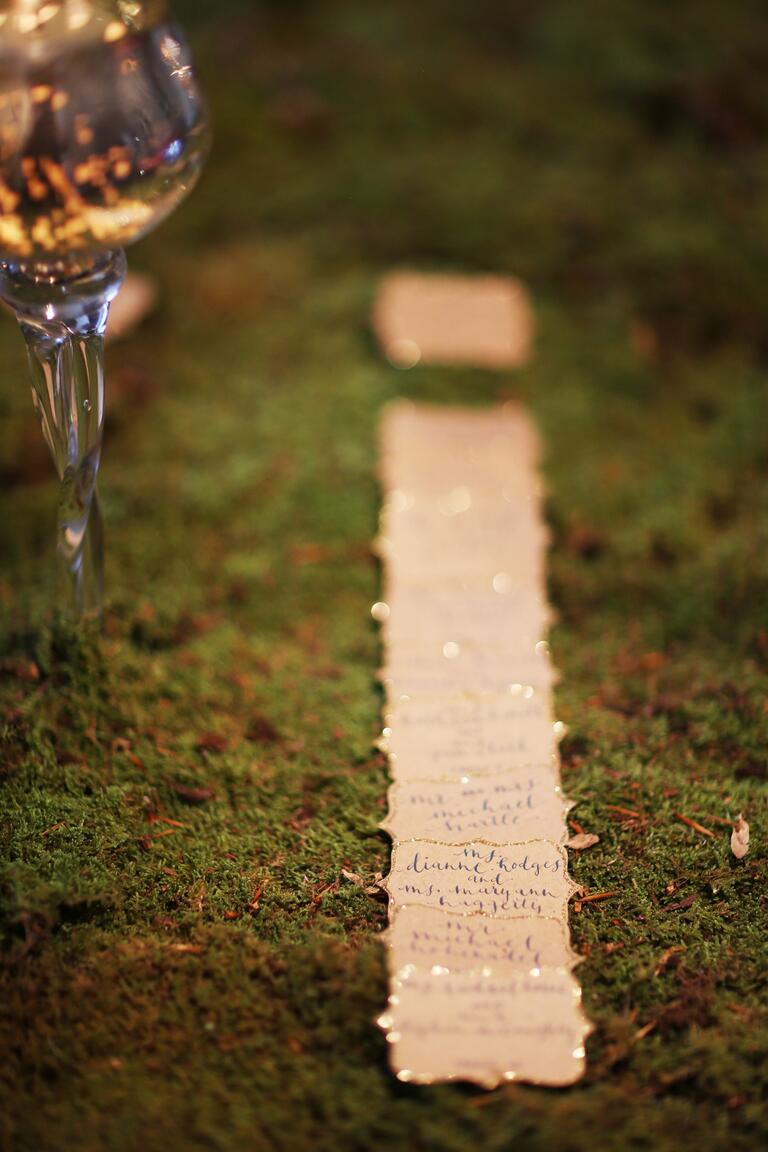 Hand Lettered Escort Cards With Glitter Edge on Moss Background