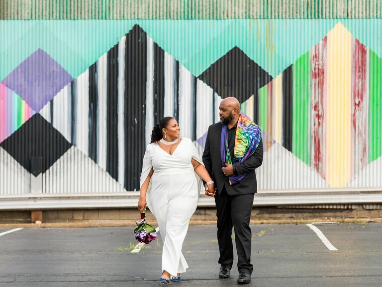 La pareja cogida de la mano caminando y sonriendo