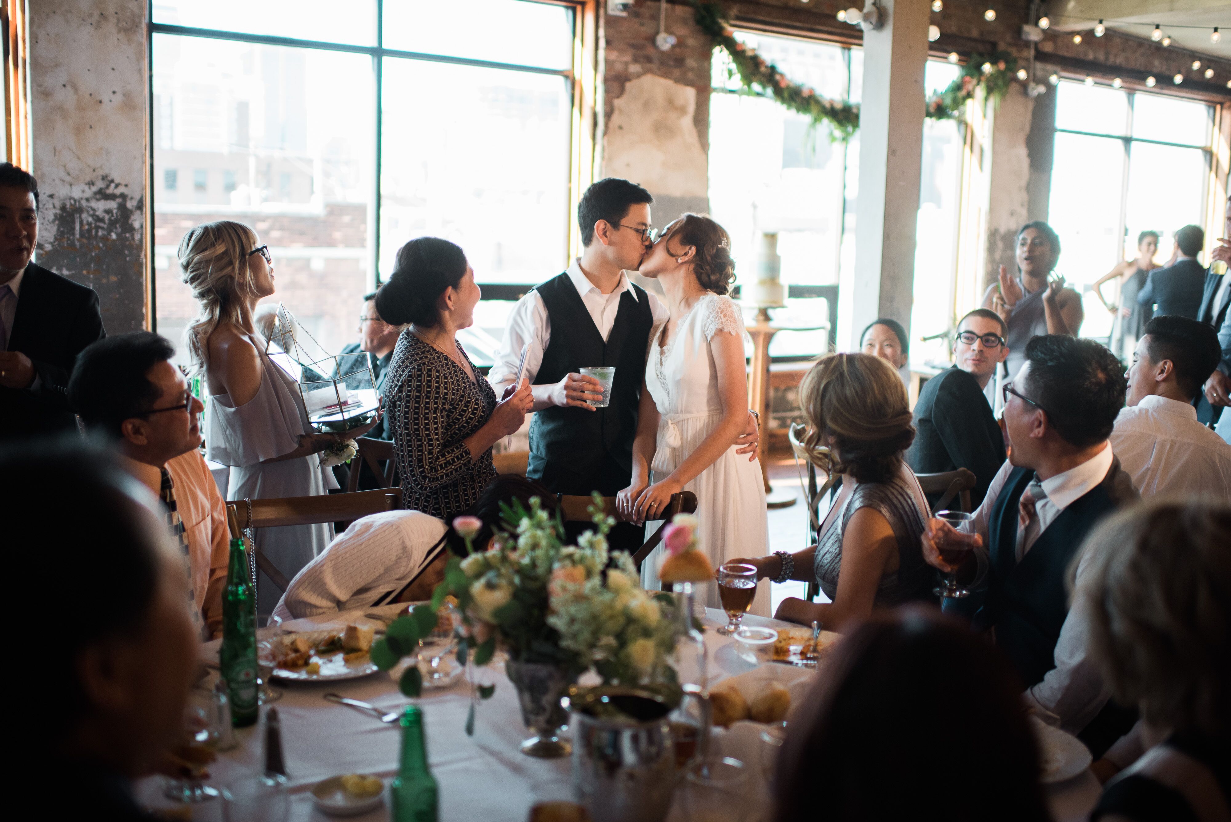 Couple Kissing with Toasts at Reception