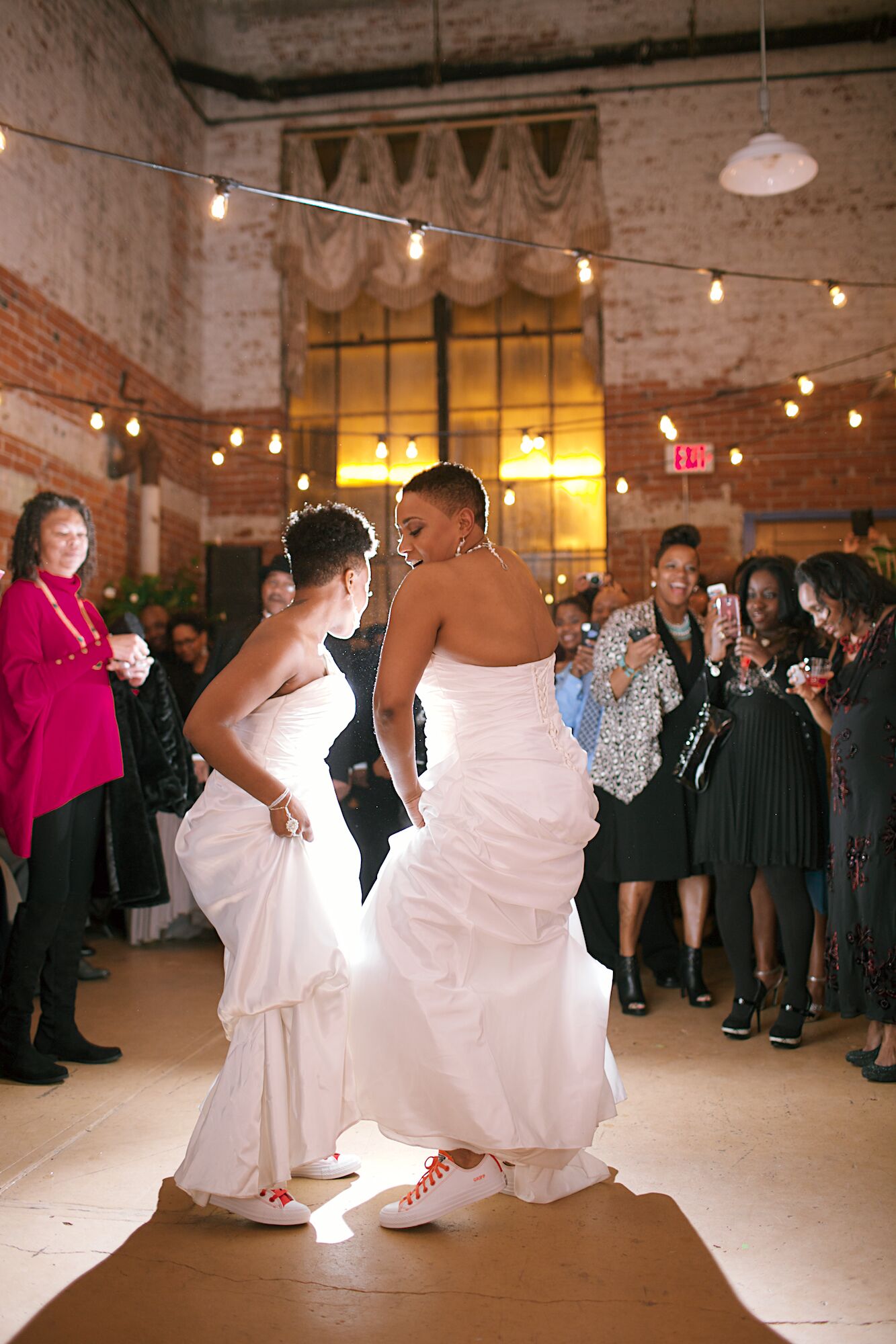 Brides Dancing in Converses Under String Lights