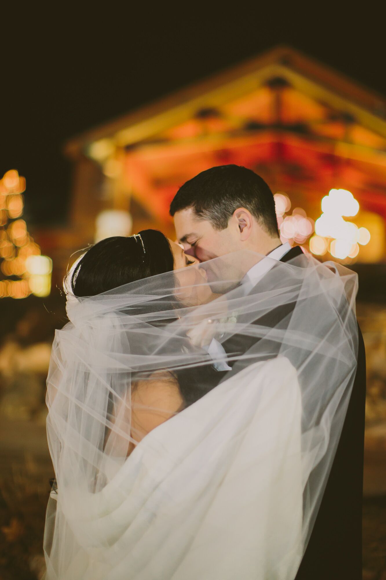 Groom And Bride In Long Veil Kiss Outside Tundra Lodge