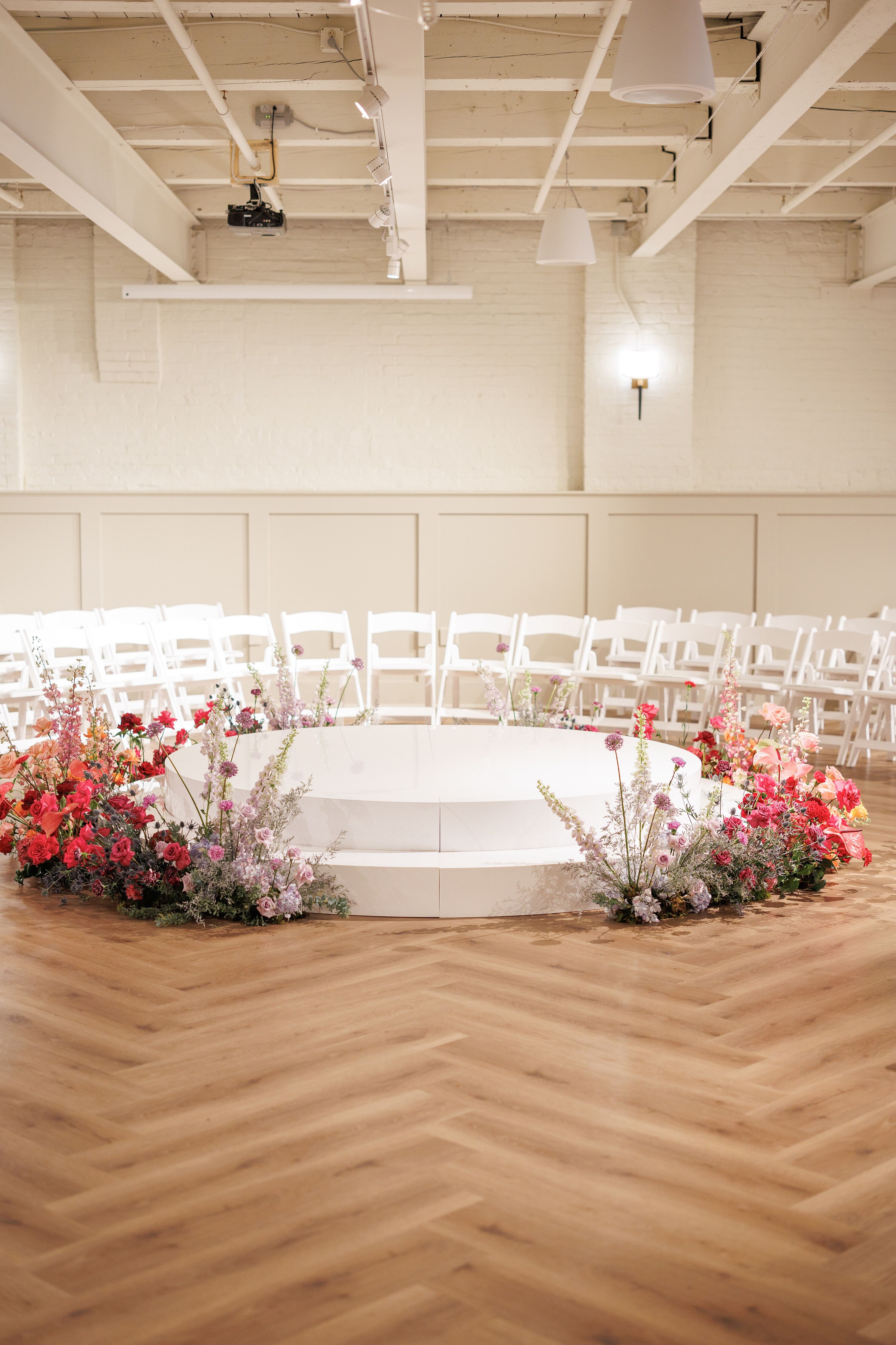 Round Ceremony Stage Surrounded by Multi-Colored Floral Arrangements