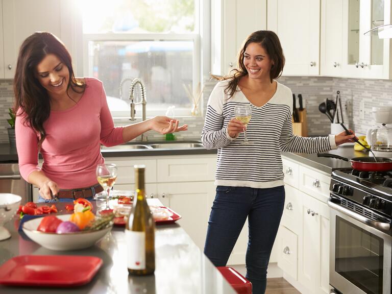 Casal sorrindo e cozinhar juntos na cozinha de casa