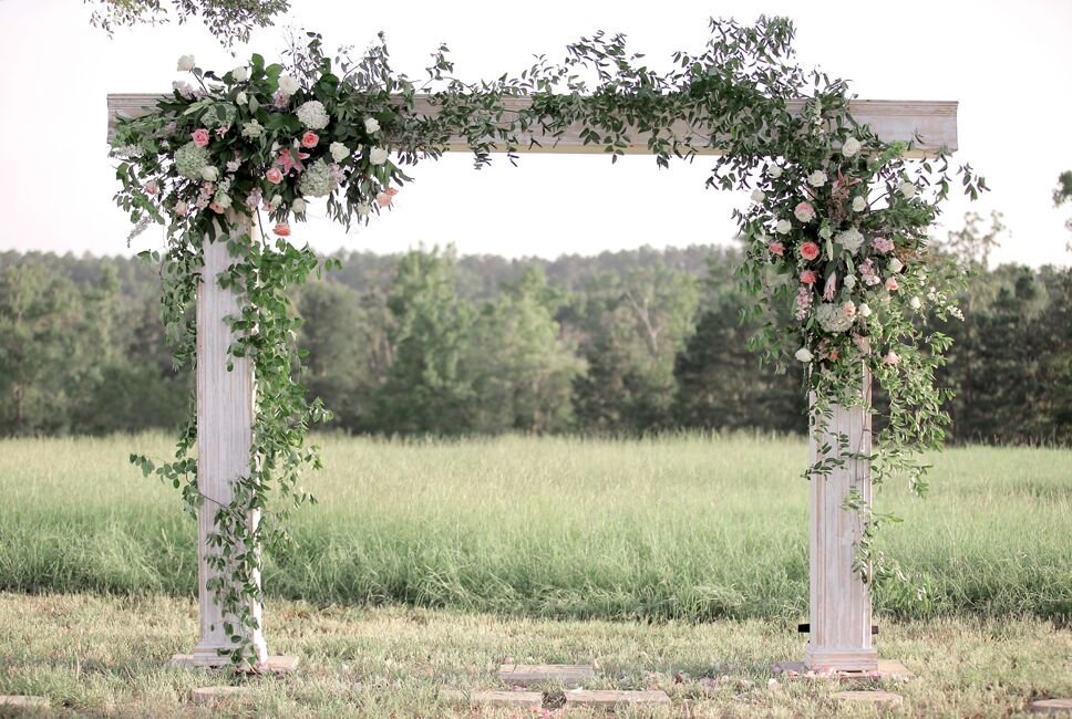 White Wooden Wedding Arch With Greenery and Flowers