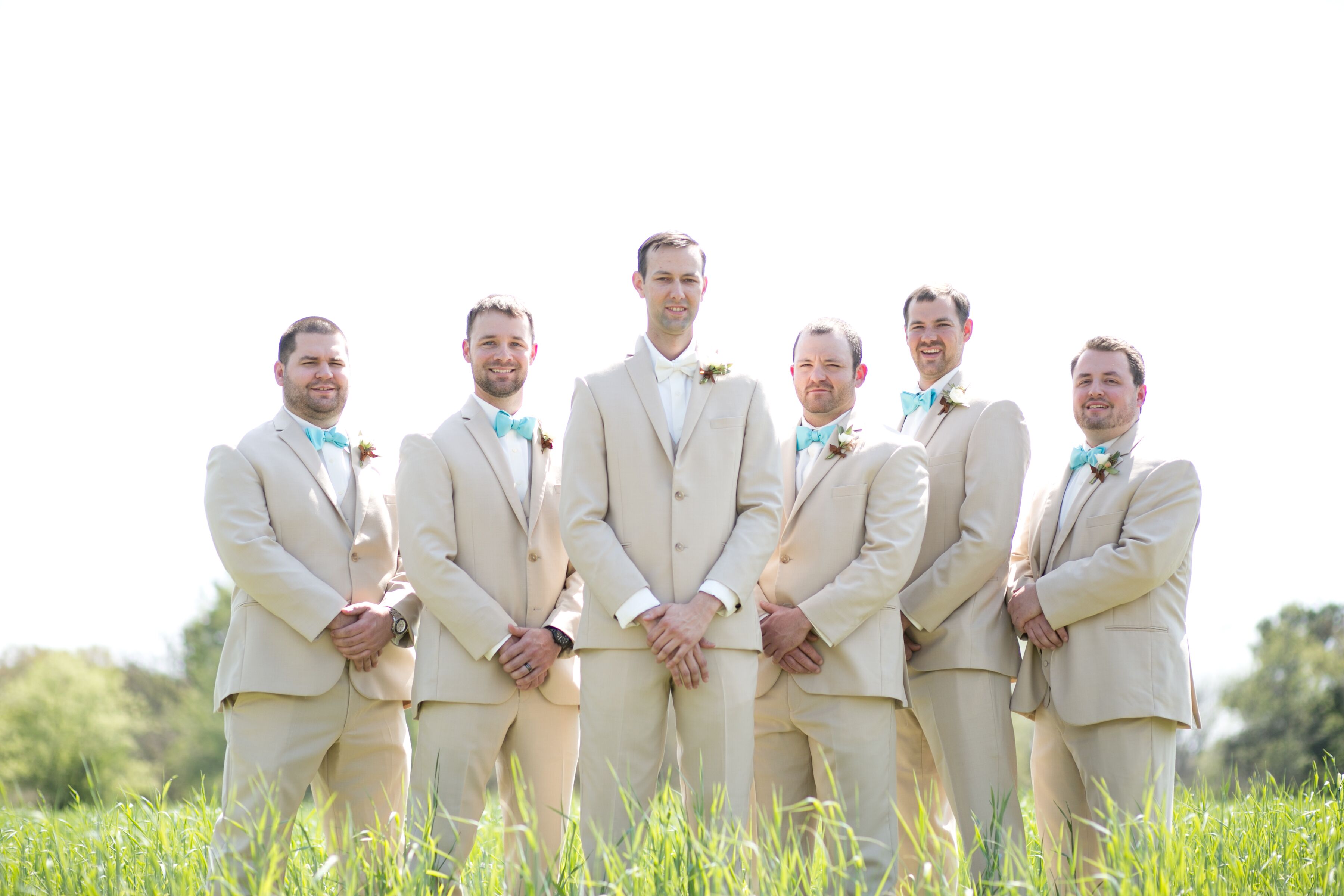 Matching Groomsmen in Tan Suits and Blue Bow Ties