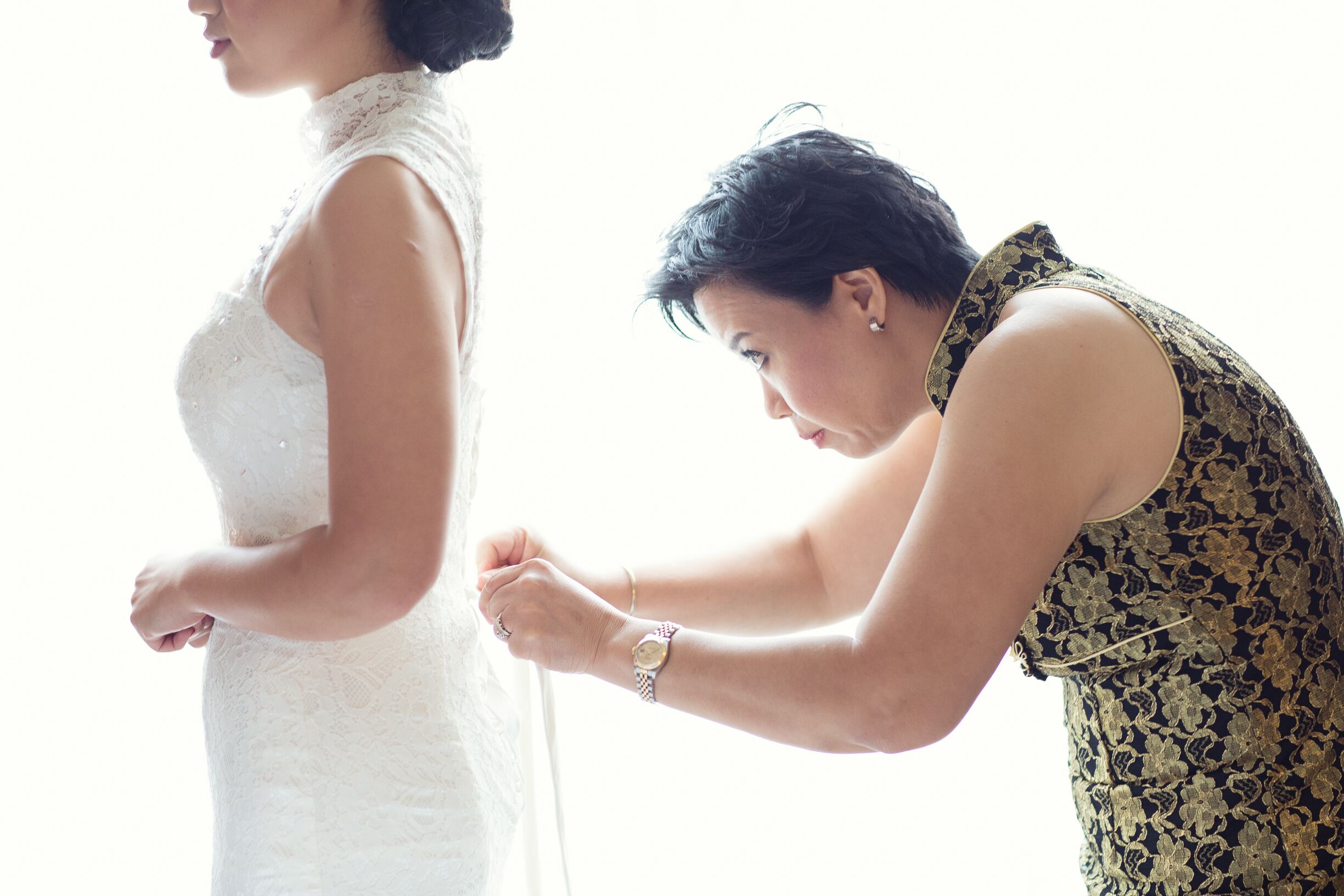 the-bride-getting-ready-in-her-chinese-wedding-dress-with-help-from-mom