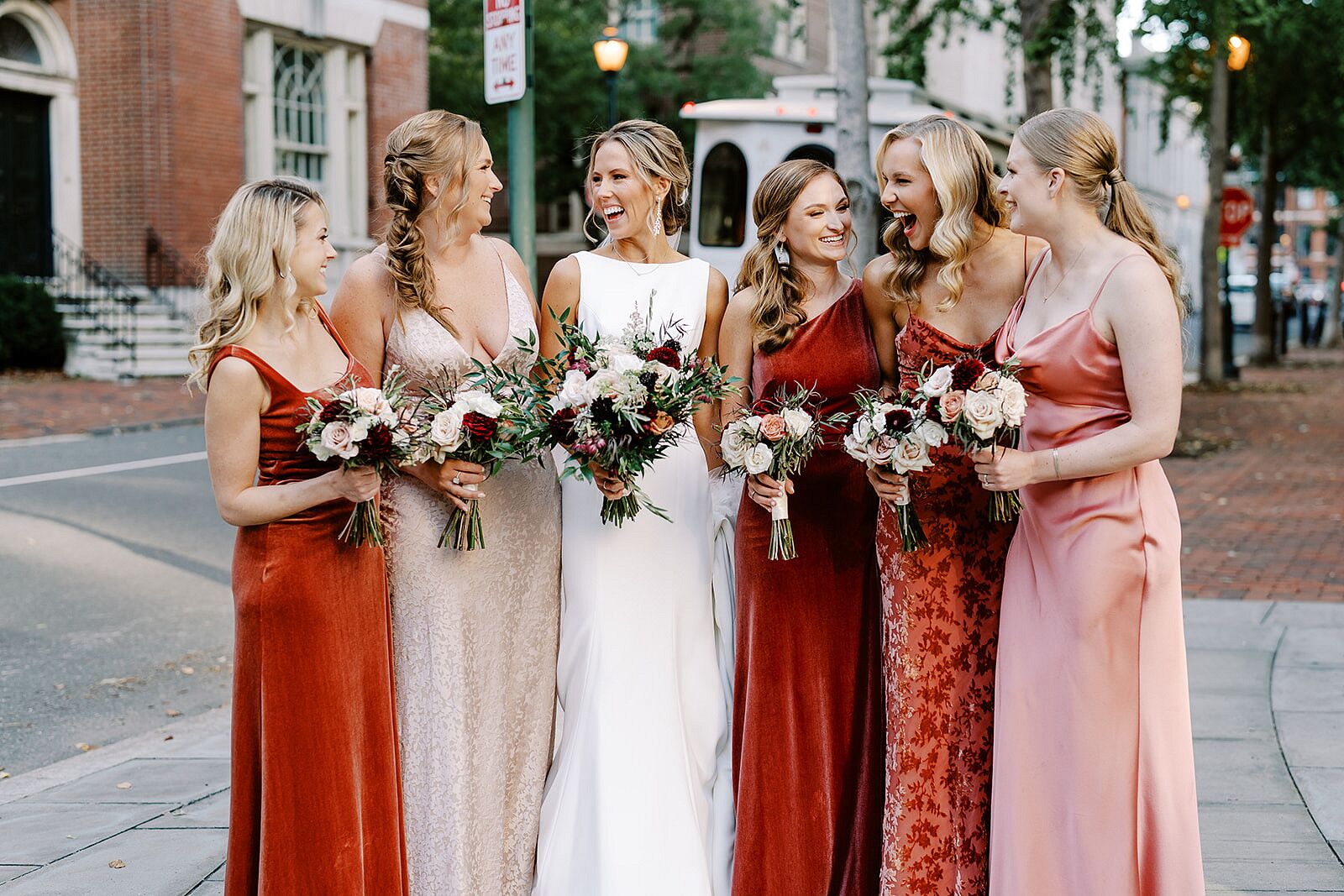 Bride in Bateau-Neck Dress With Brides in Champagne, Red and Blush Dresses