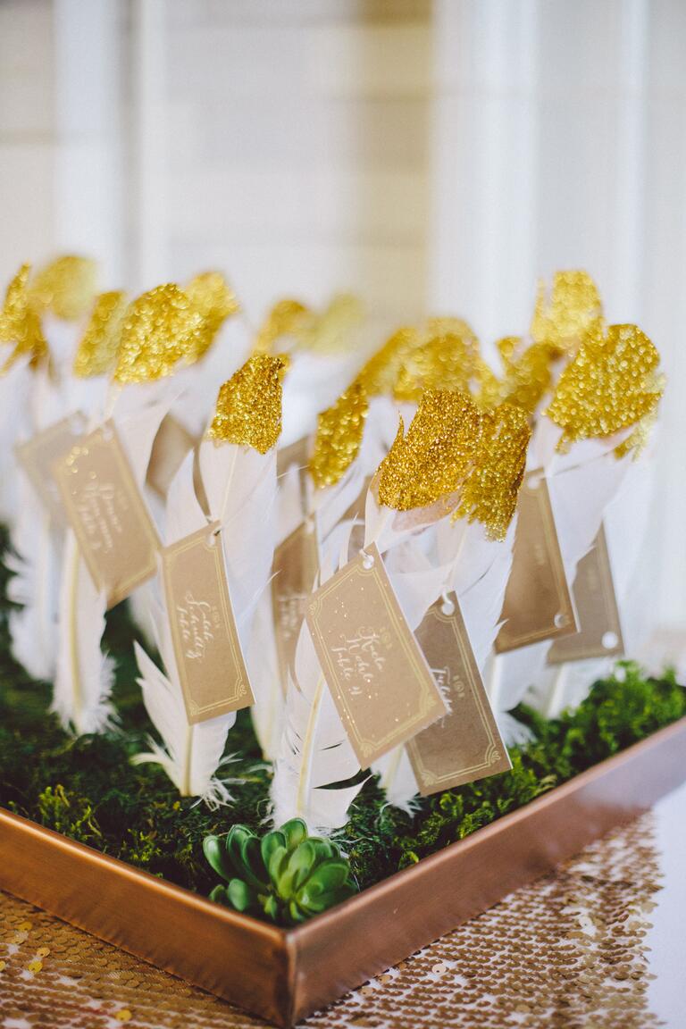 White escort card feathers with gold accent