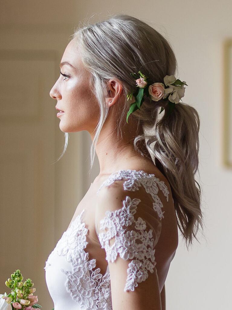 bröllopshår blommor ovanför låg hästsvans