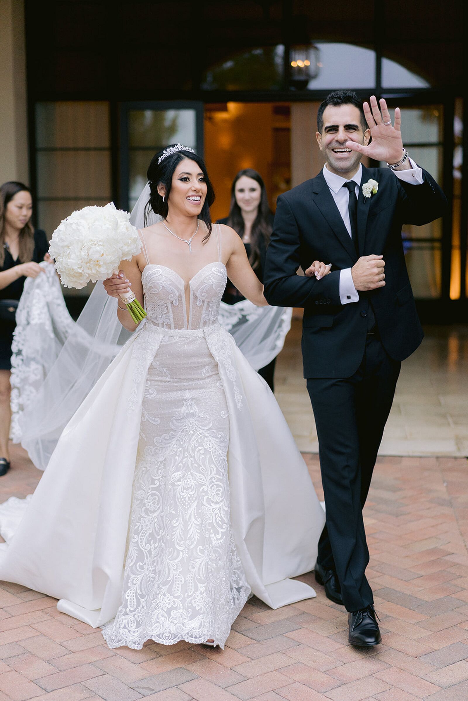 Bride in Sheer Sweetheart Wedding Dress With Overskirt and Groom in ...