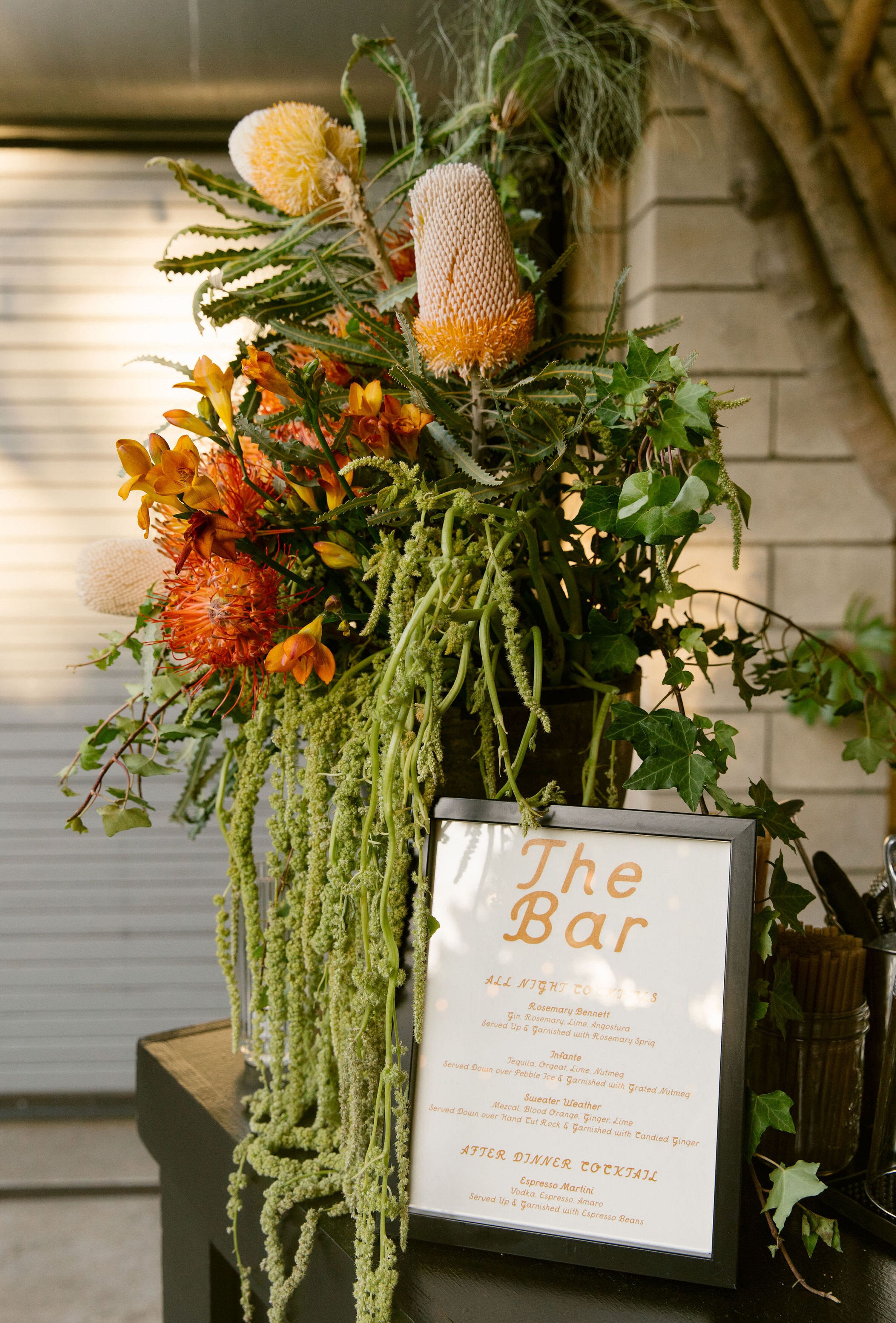 Outdoor Cocktail Menu Display With Orange Banksia, Freesia and ...
