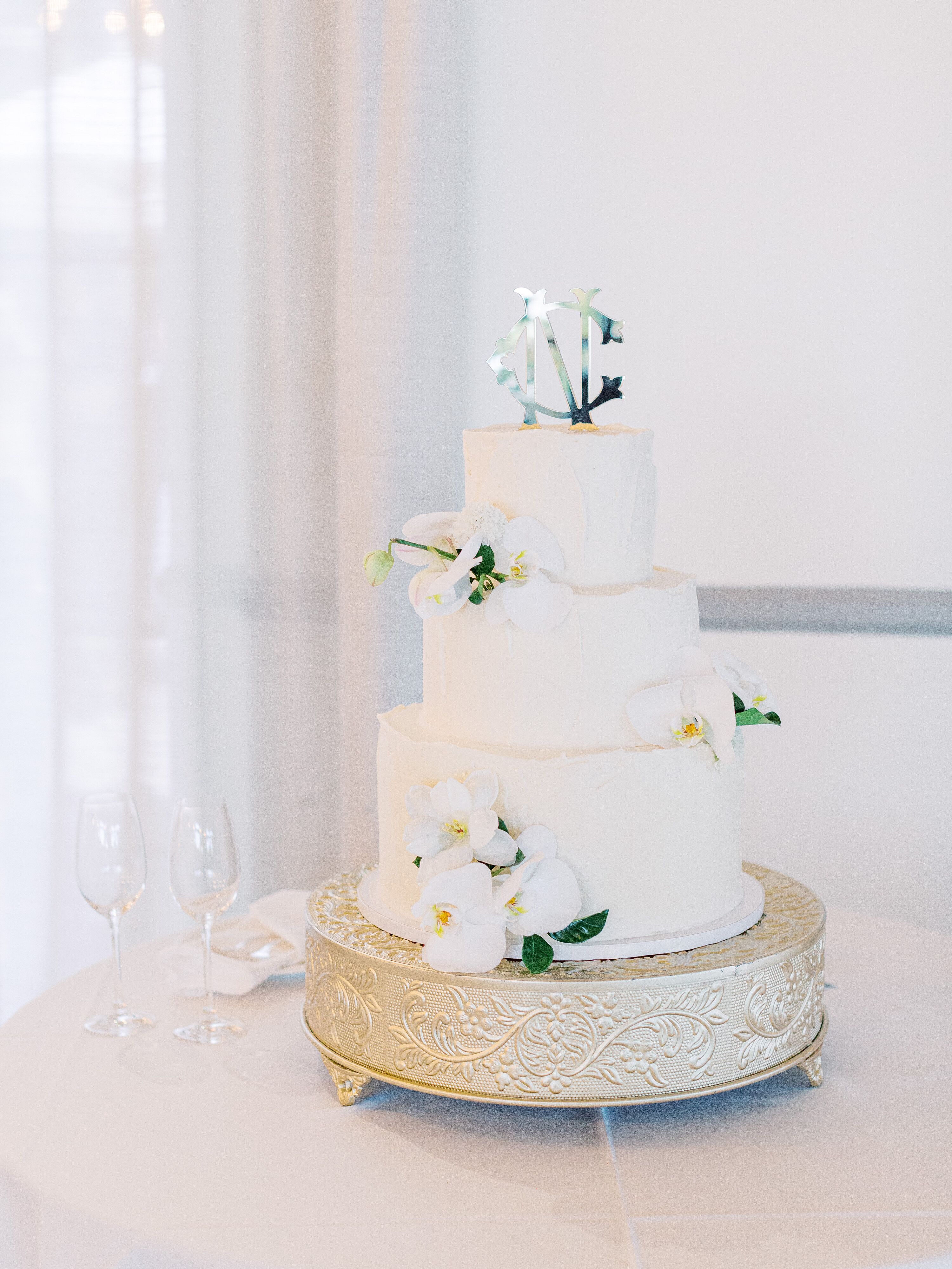 Three-Tiered Round Wedding Cake With White Orchids and a Silver ...