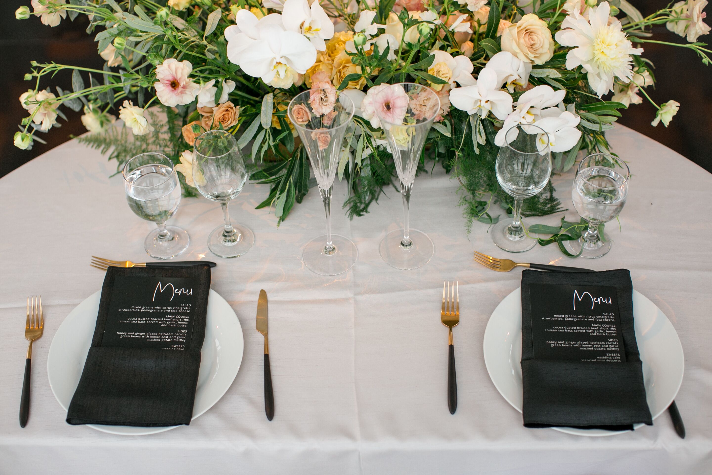 Elegant Place Setting with Black Menus and Gold Flatware