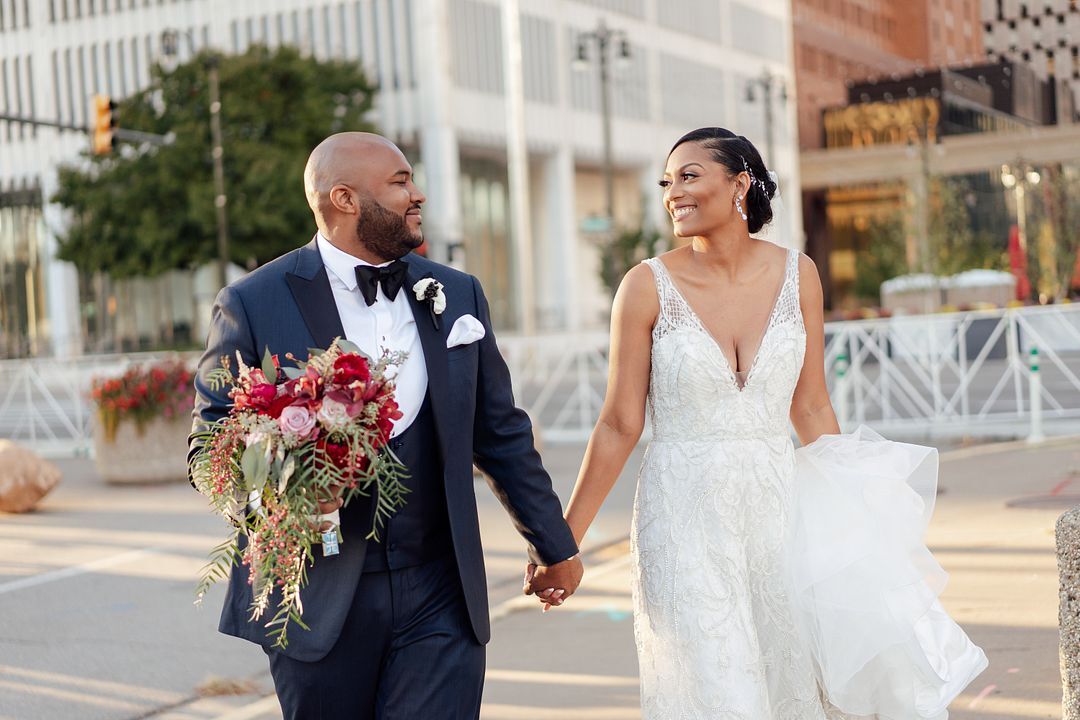 bride and groom holding hands around door