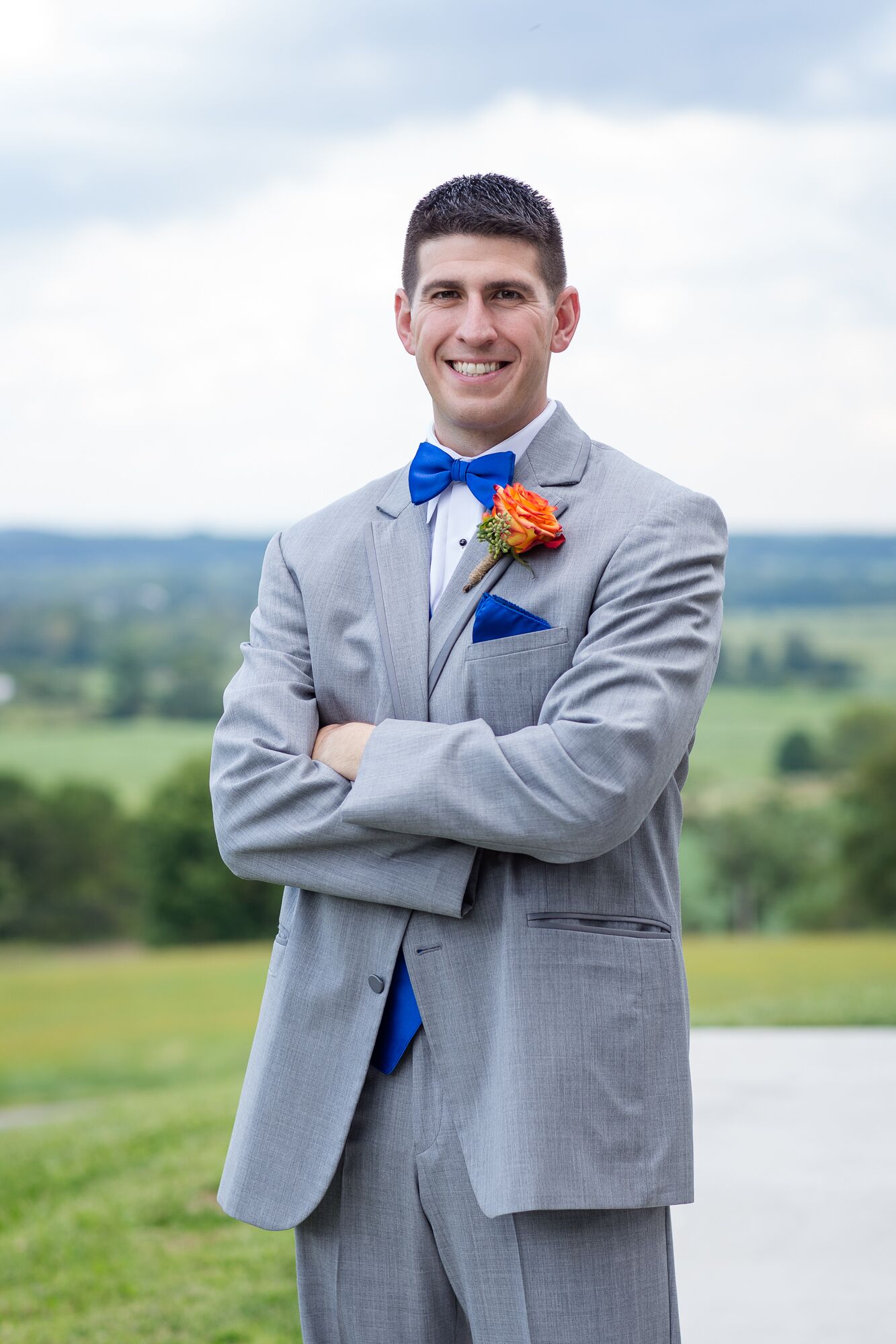 Grooms Gray Suit with Bright Blue Bow Tie and Orange Rose Boutonniere