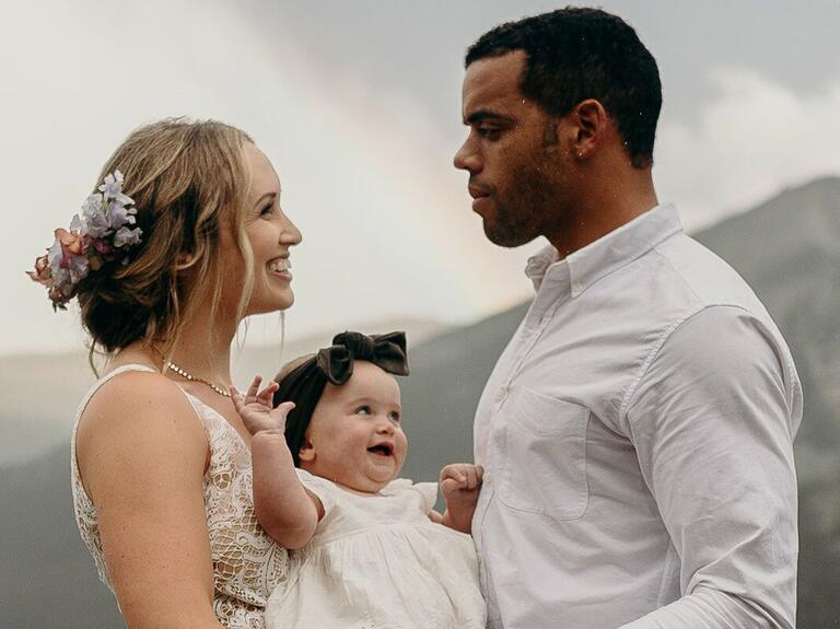 wedding hair flowers couple with baby and bride wearing light colored flowers