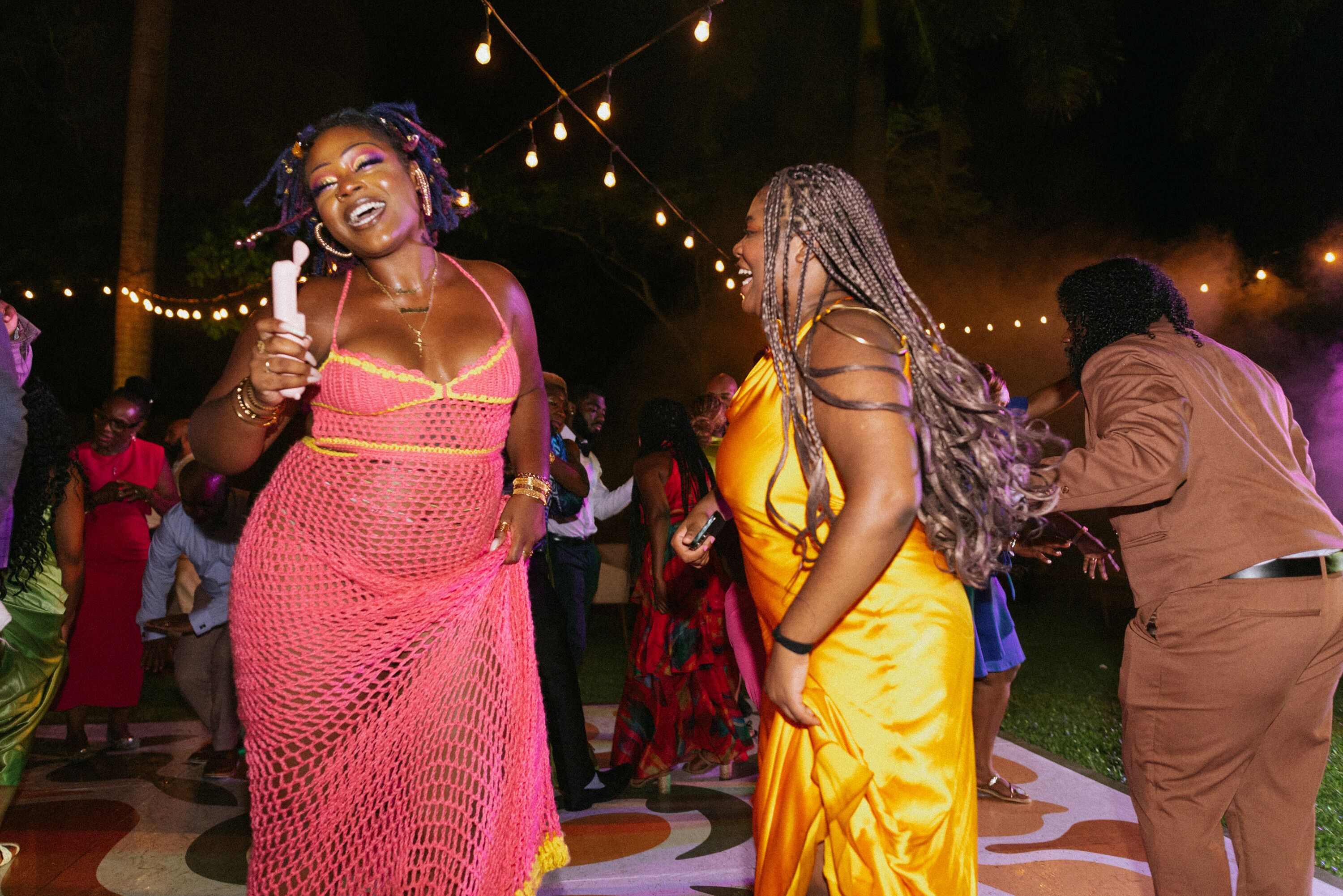 Wedding Guests in Tropical Attire Dancing on Outdoor Dance Floor Under ...