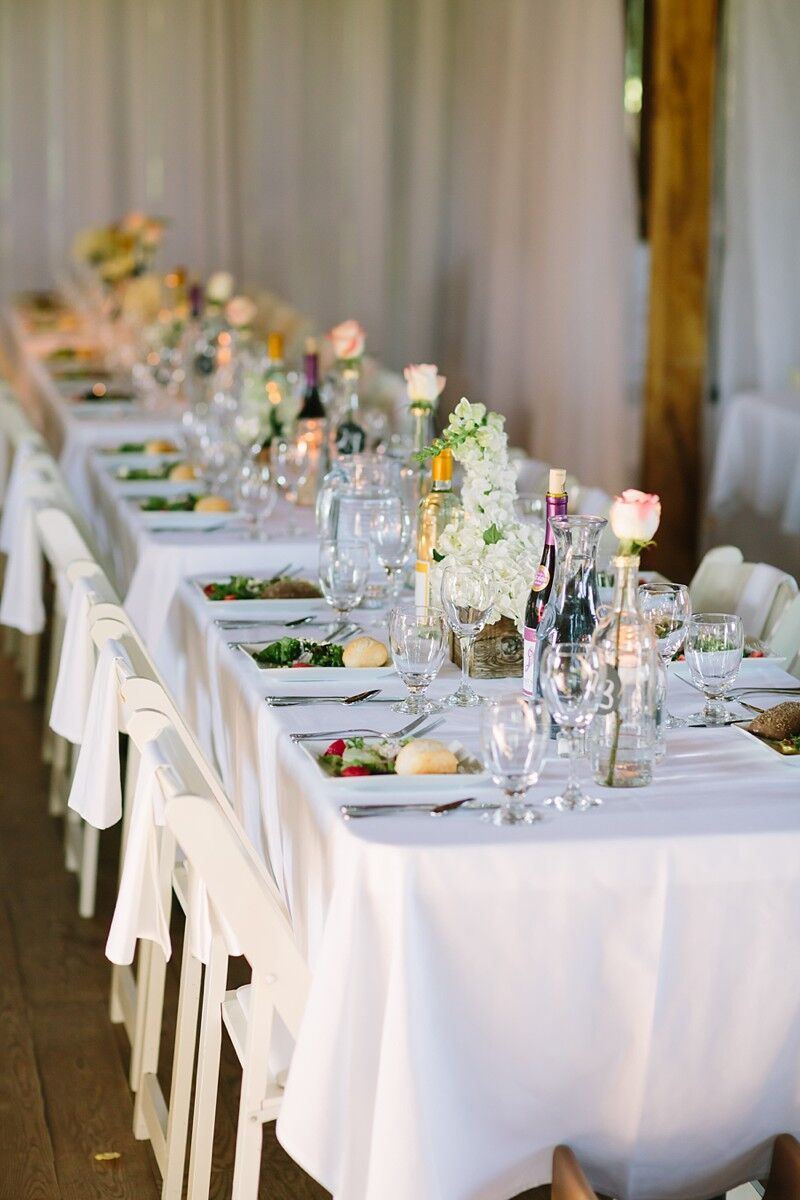 Rustic Table Decor with Wine Bottles, Roses, and Hydrangeas at The ...