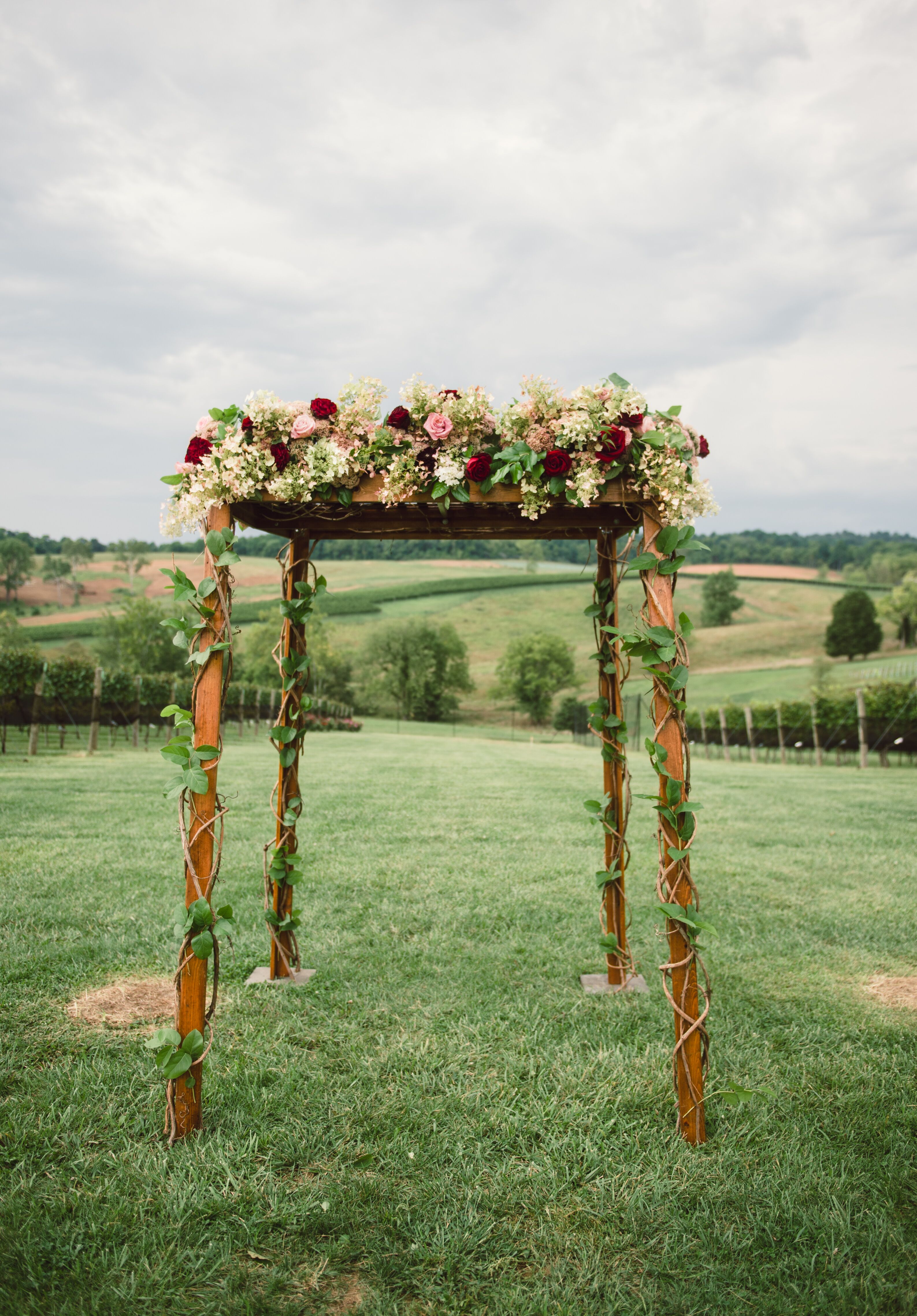 Wood Frame Chuppah with Burgundy and Pink Flowers and Vines